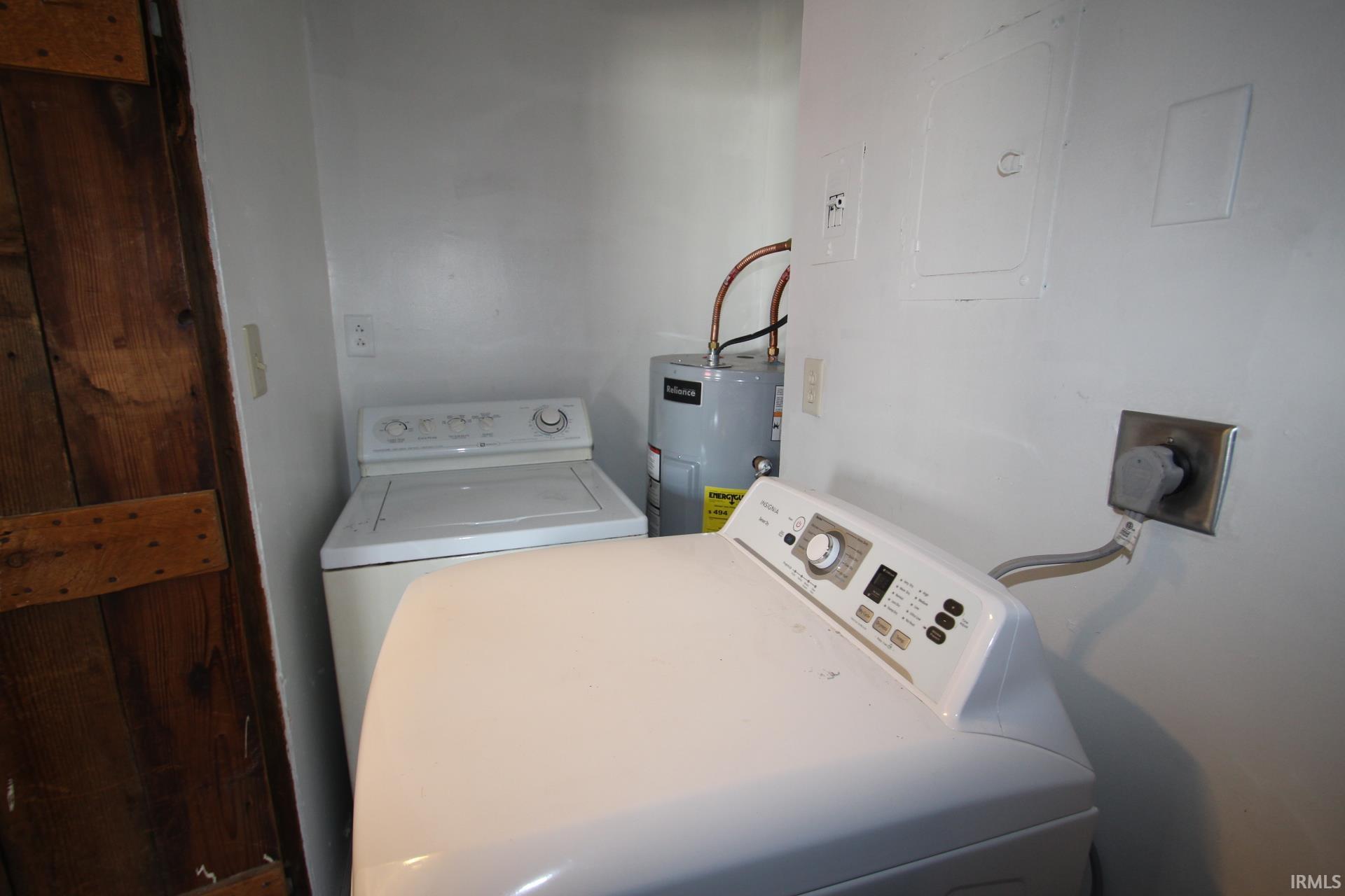 Laundry area with electric panel and electric water heater
