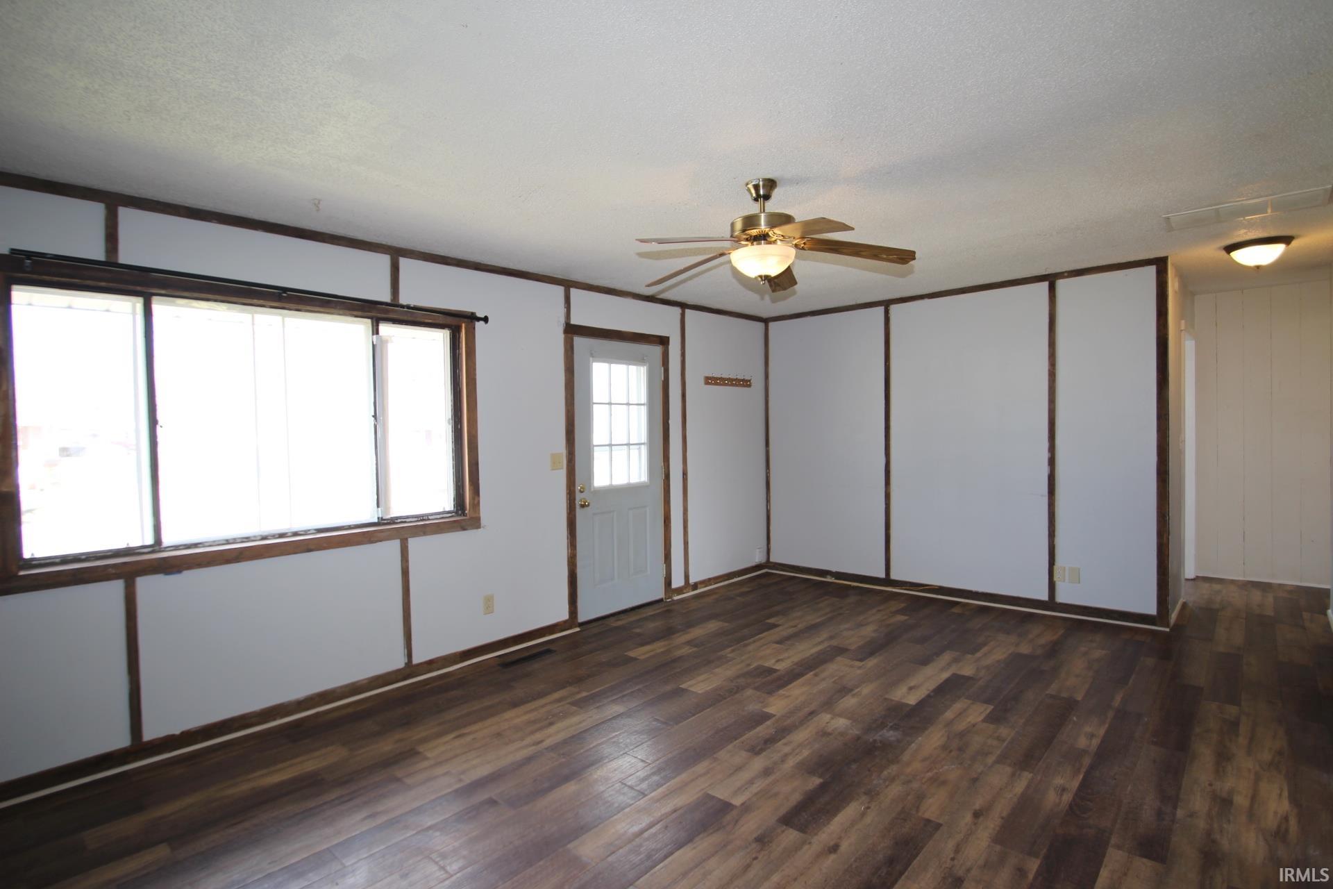 Unfurnished room with a ceiling fan and dark wood-style floors