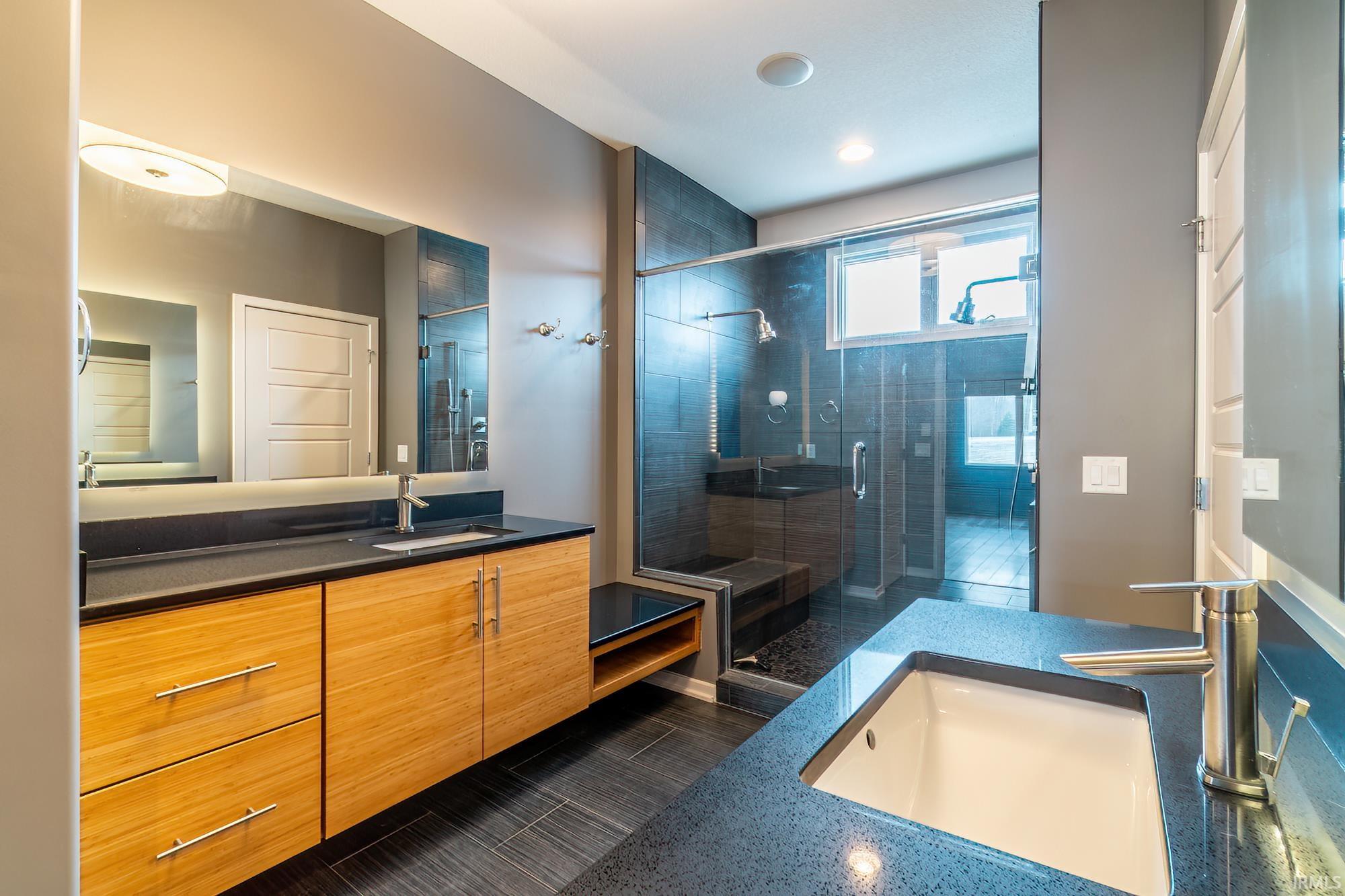 Bathroom featuring two vanities and a shower stall