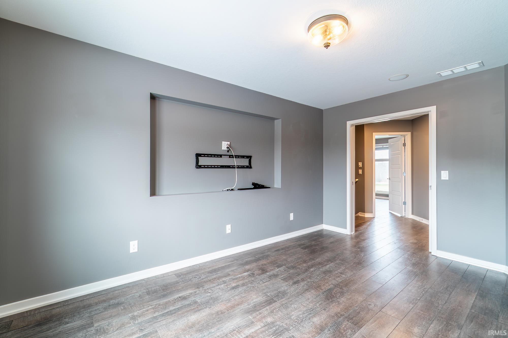 Empty room with baseboards and dark wood finished floors