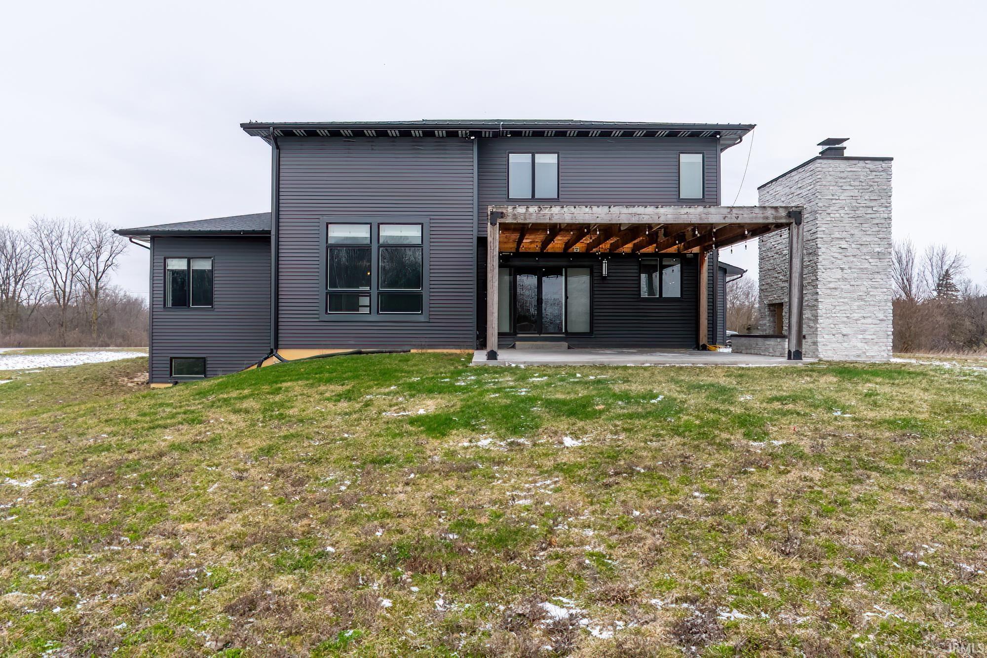 Back of property featuring a patio, a lawn, and a chimney