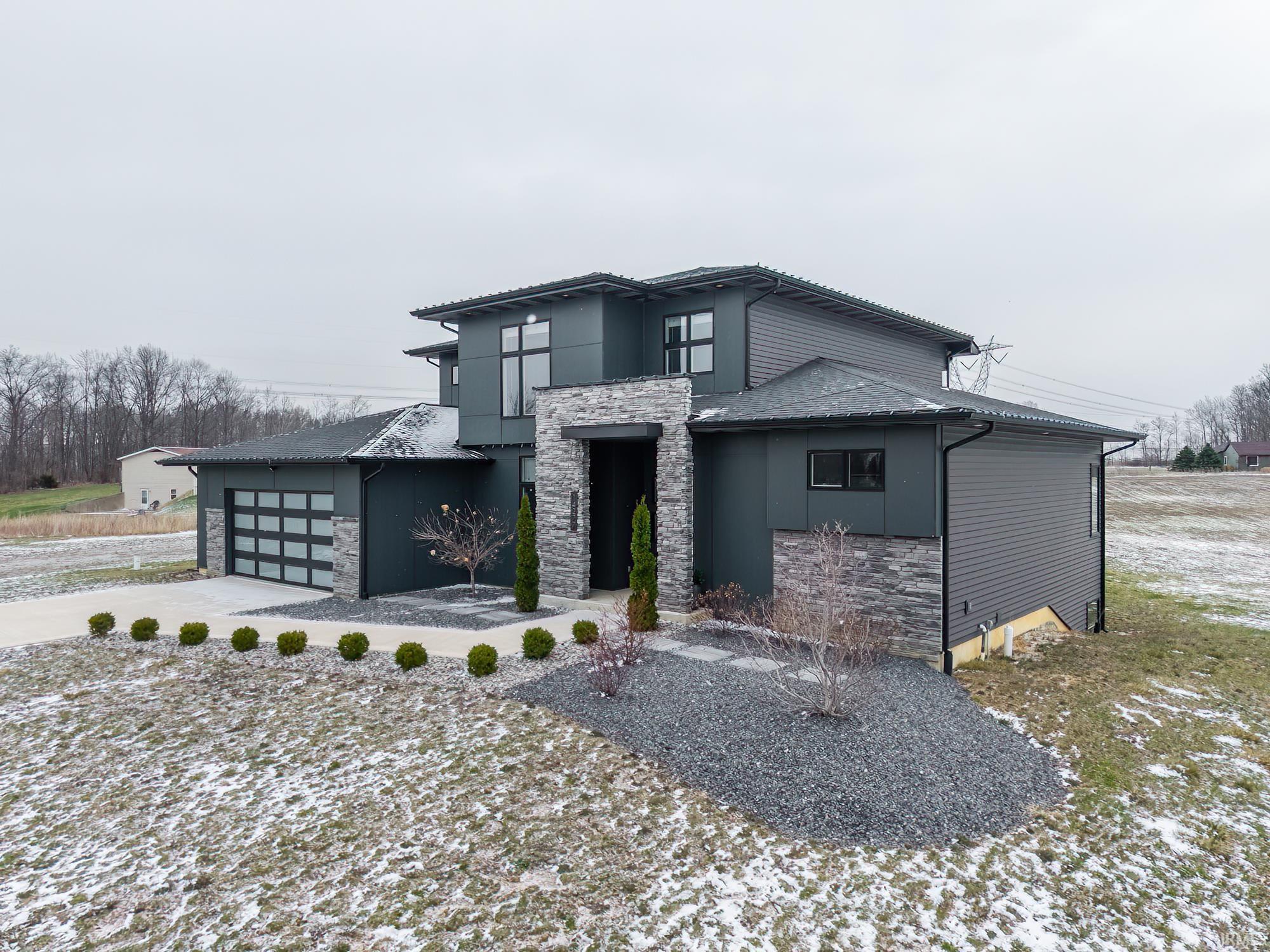 View of front of home with stone siding, an attached garage, stucco siding, and driveway