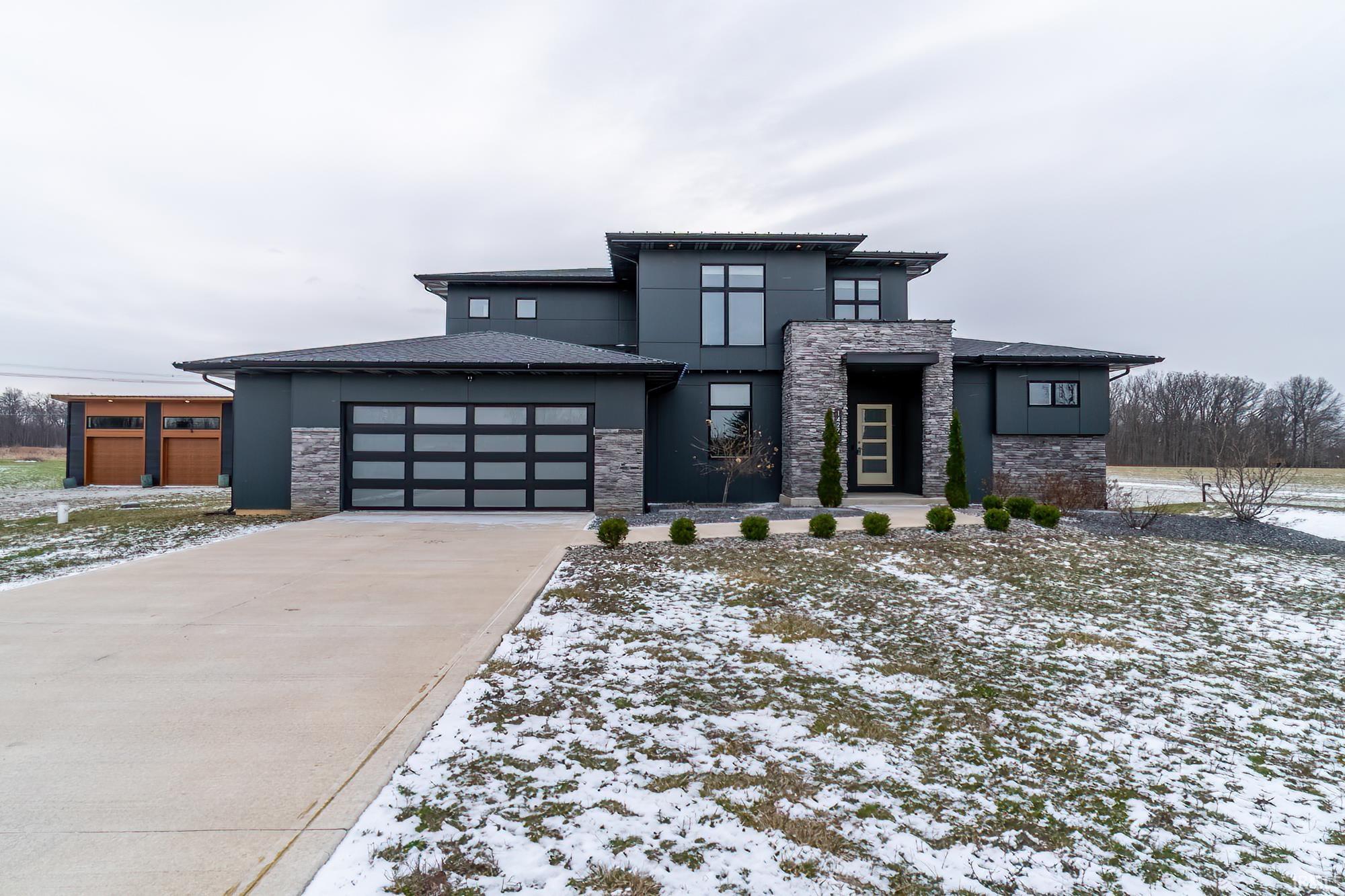 Prairie-style home with stone siding, stucco siding, driveway, and an attached garage