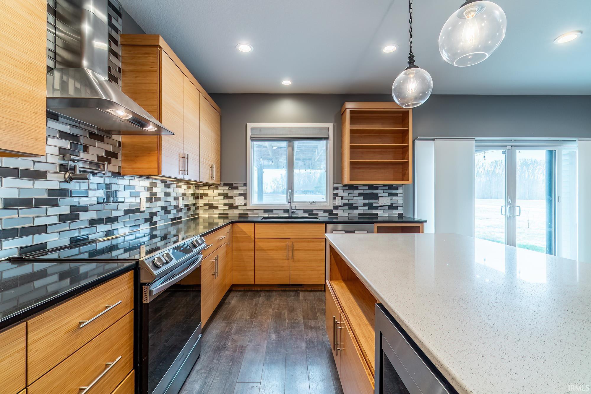 Kitchen featuring electric stove, open shelves, dark stone counters, dark wood-type flooring, and pendant lighting
