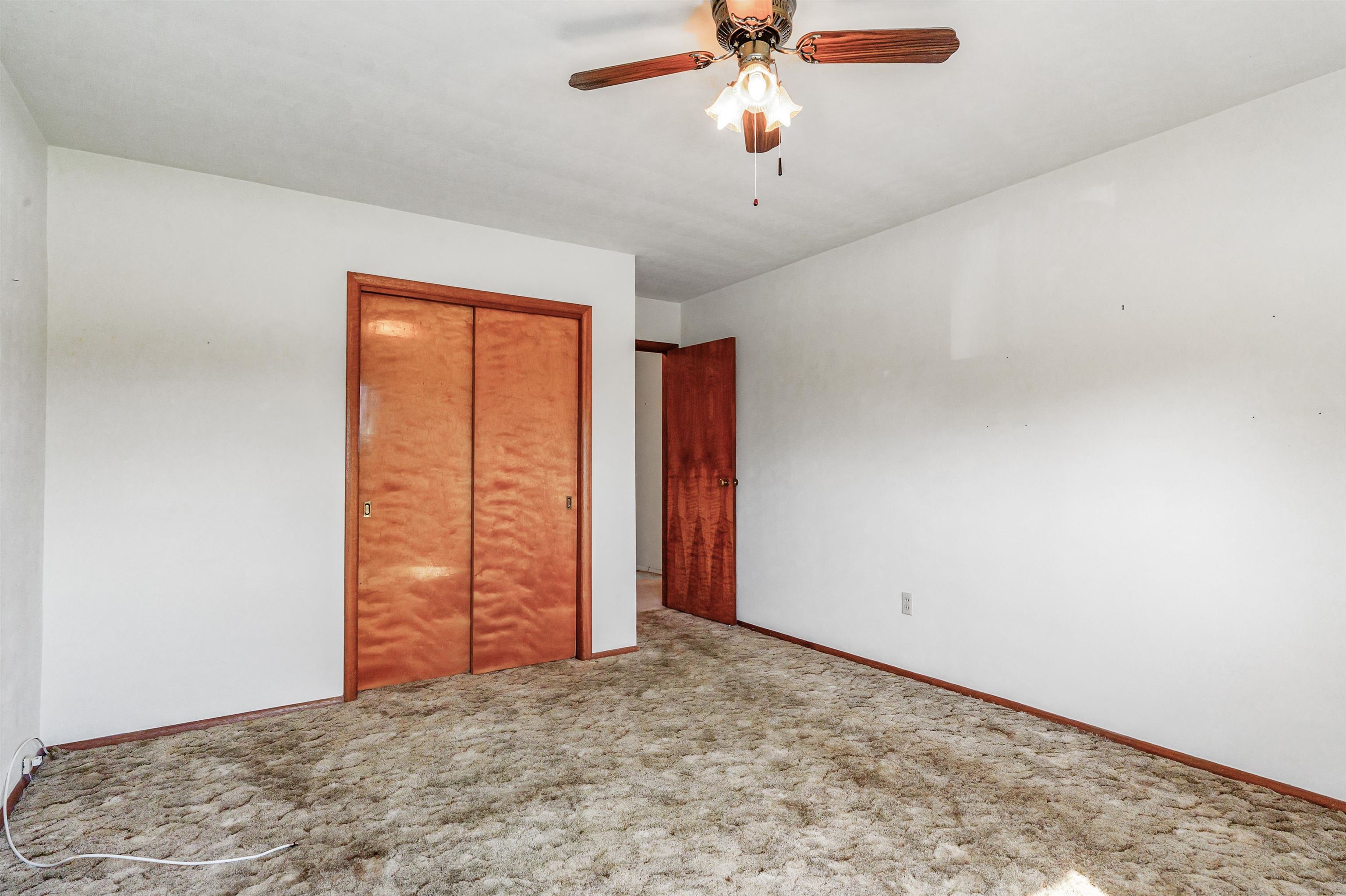 Unfurnished bedroom featuring a closet, carpet flooring, and ceiling fan