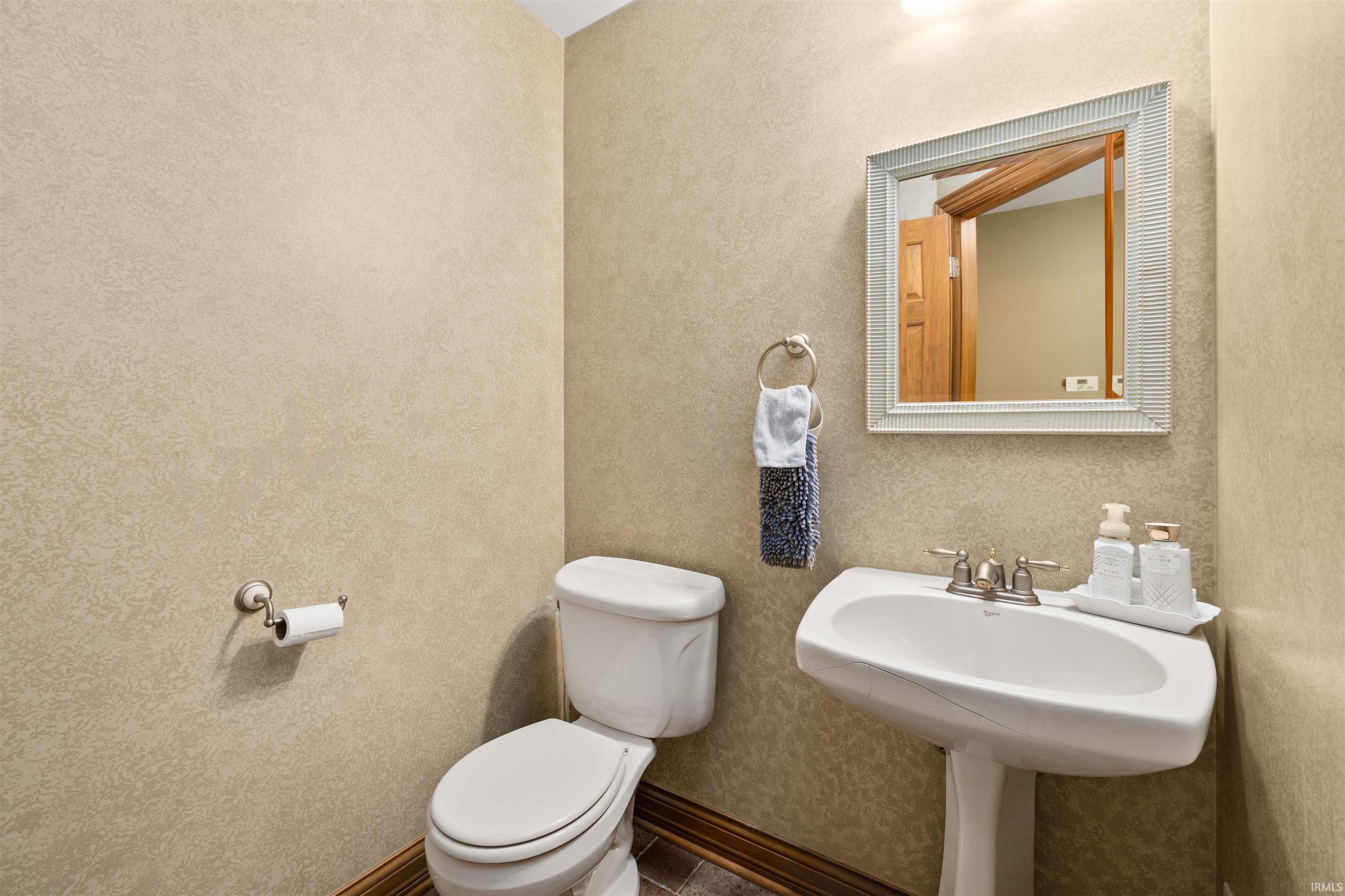 Half bath with toilet and baseboards