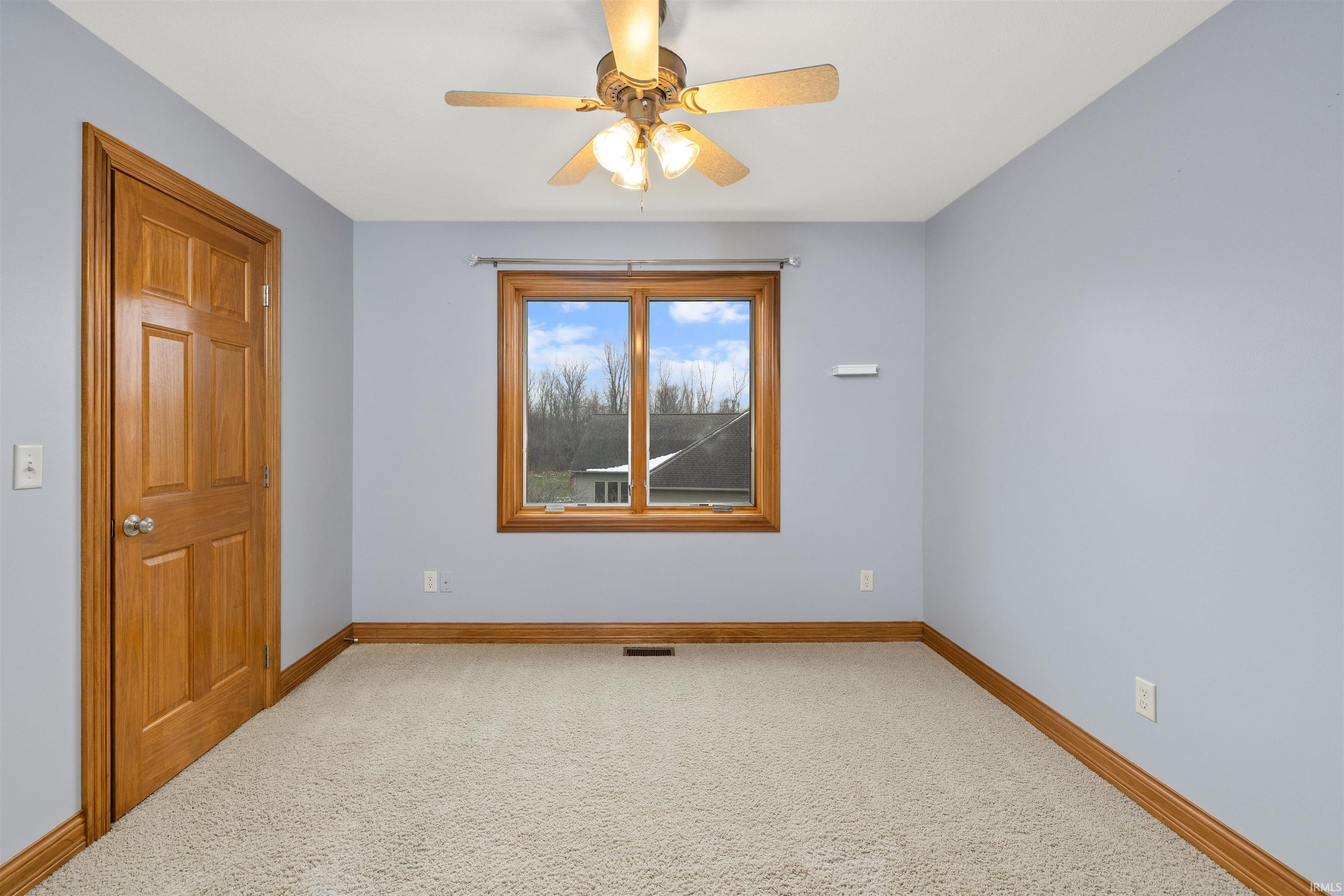 Spare room featuring ceiling fan and light colored carpet