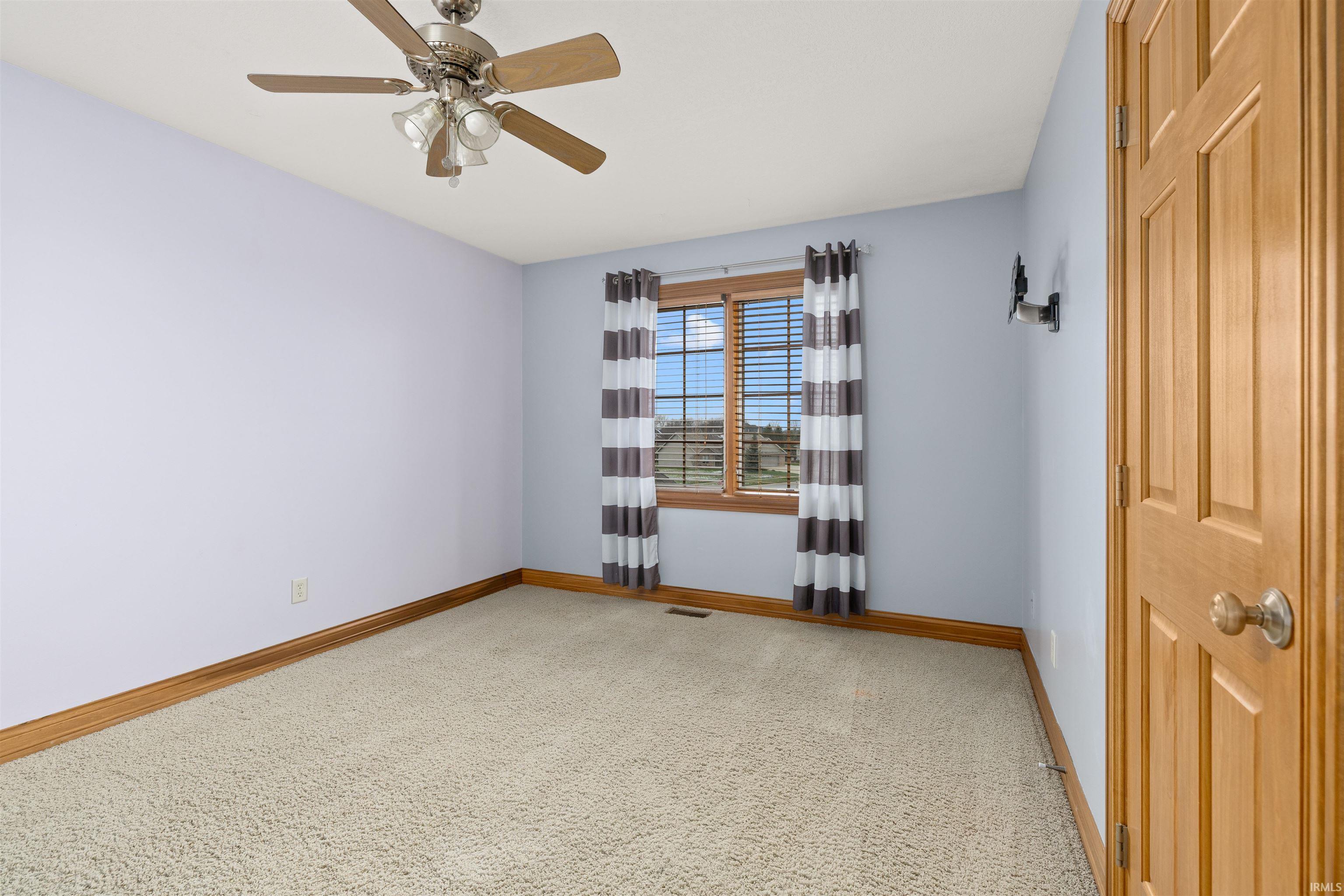 Unfurnished room featuring light carpet and ceiling fan