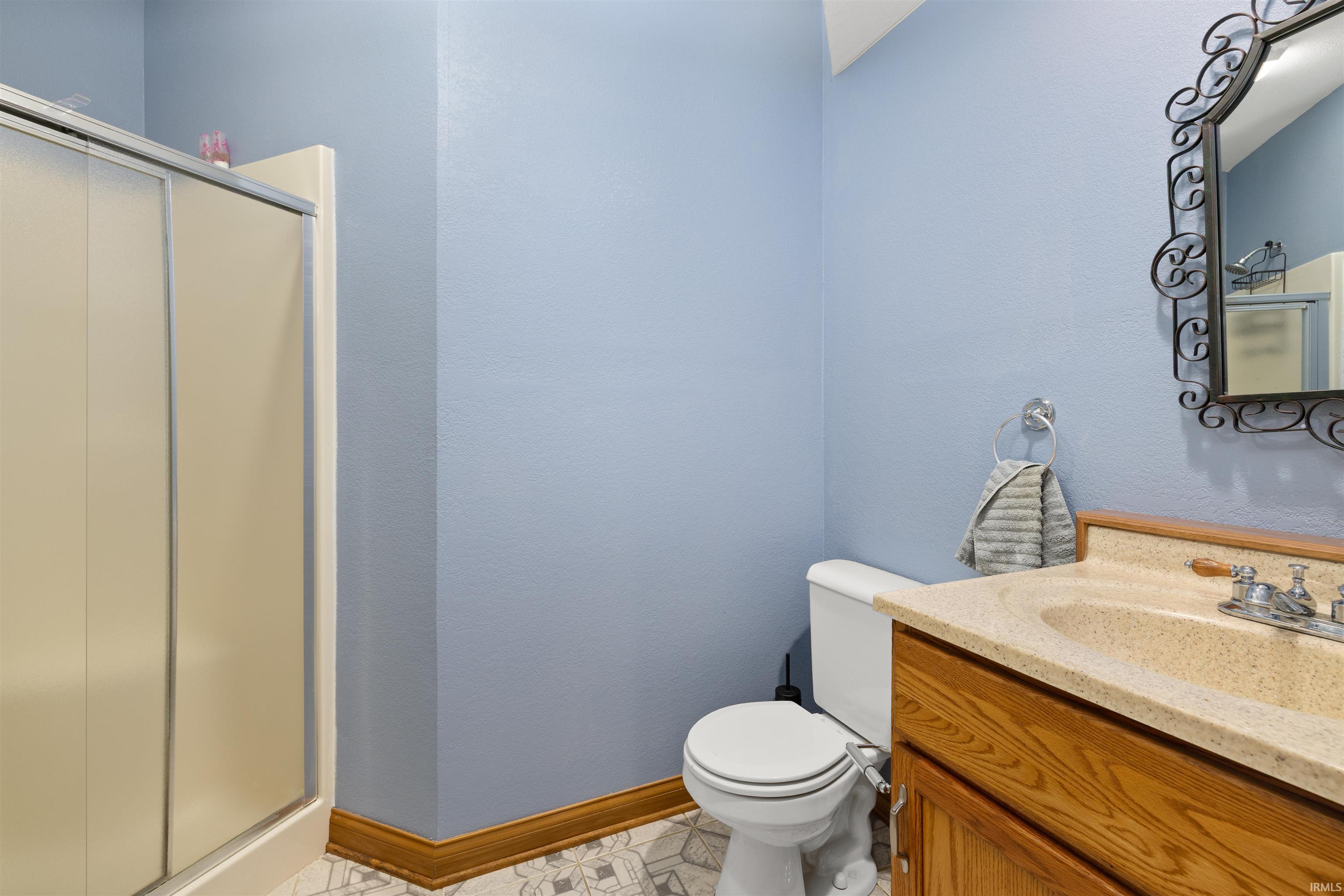 Full bath with a shower stall and vanity