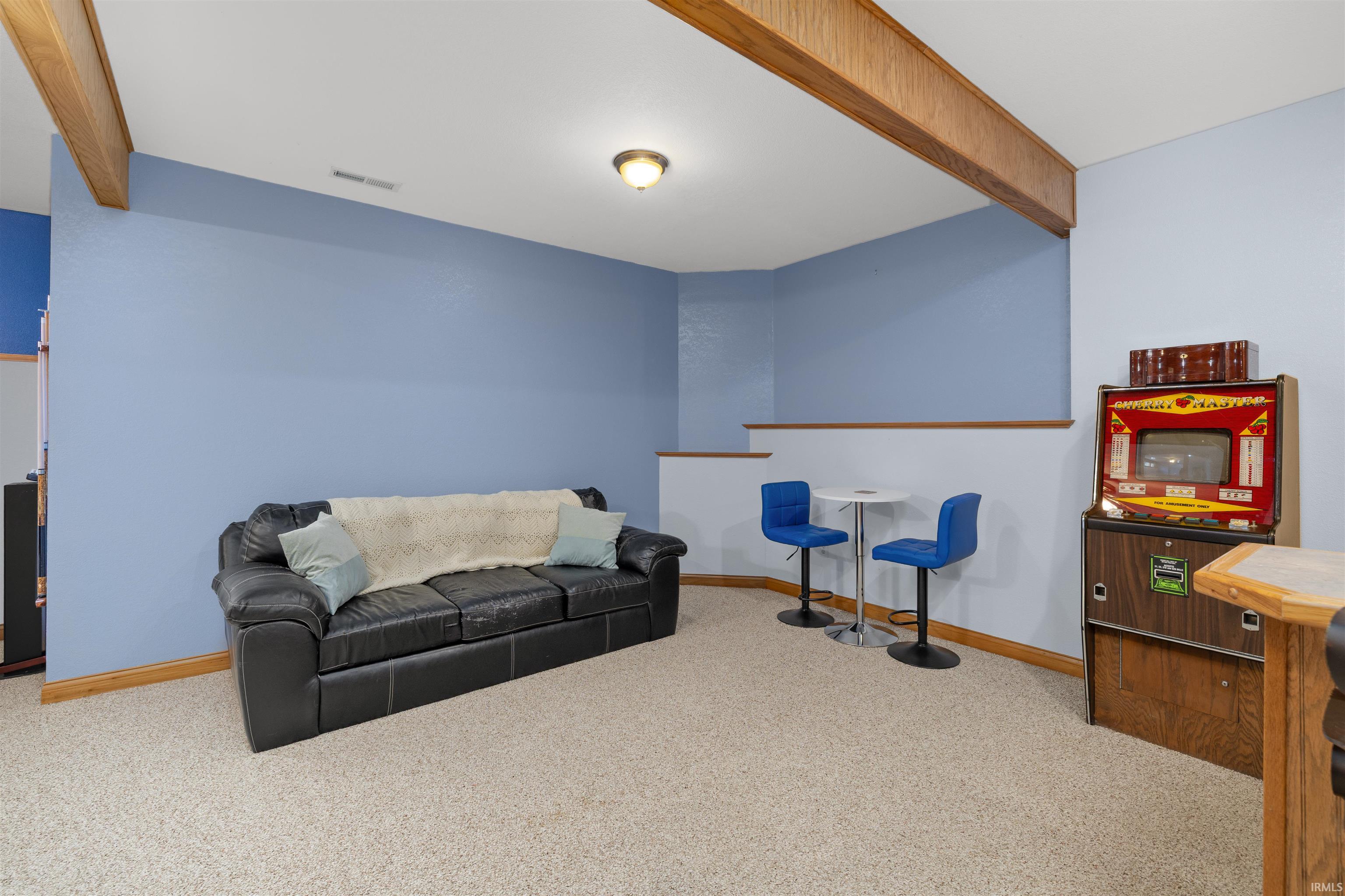 Living room featuring beam ceiling and light colored carpet