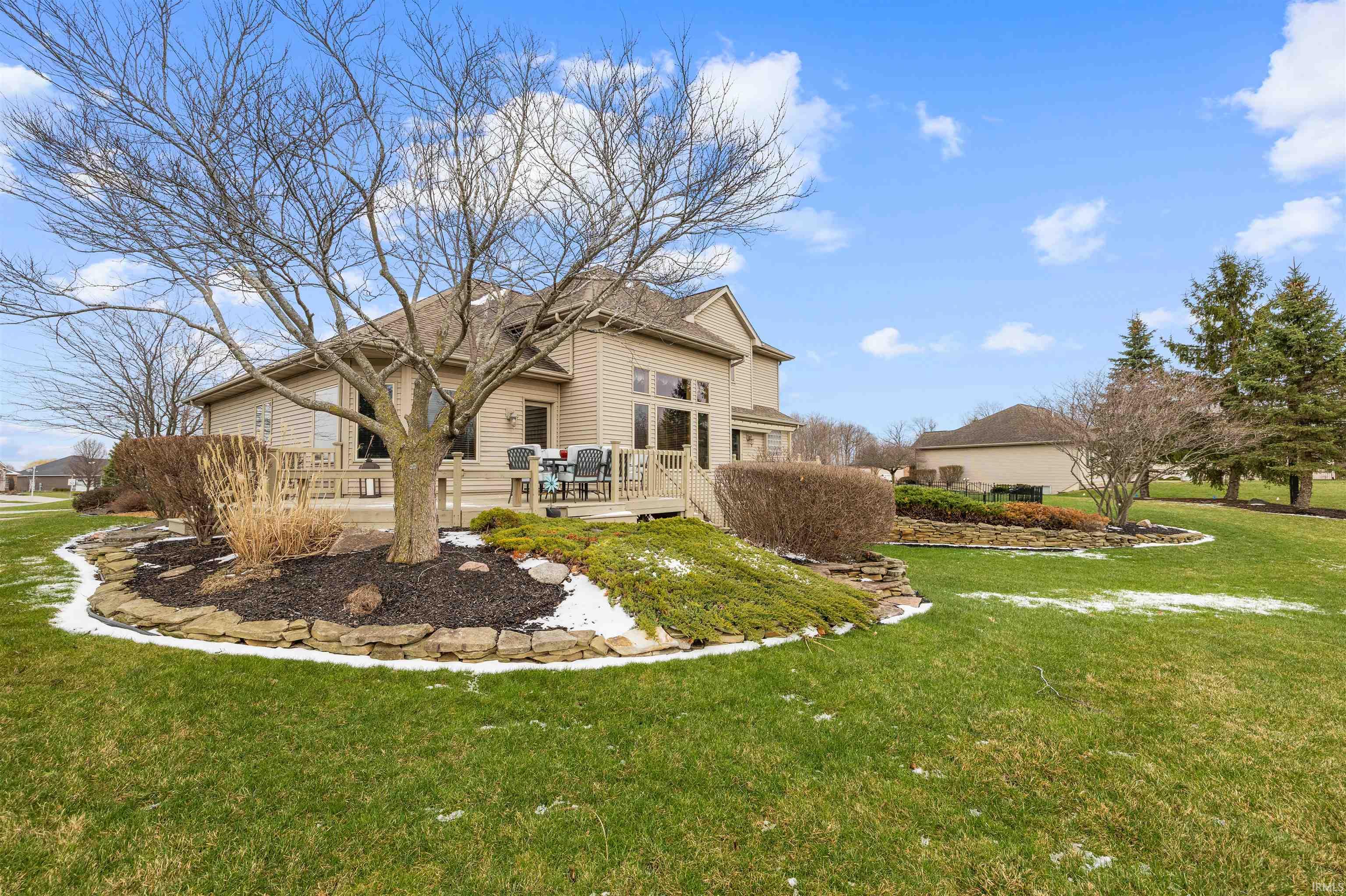 Rear view of house with a wooden deck and a yard
