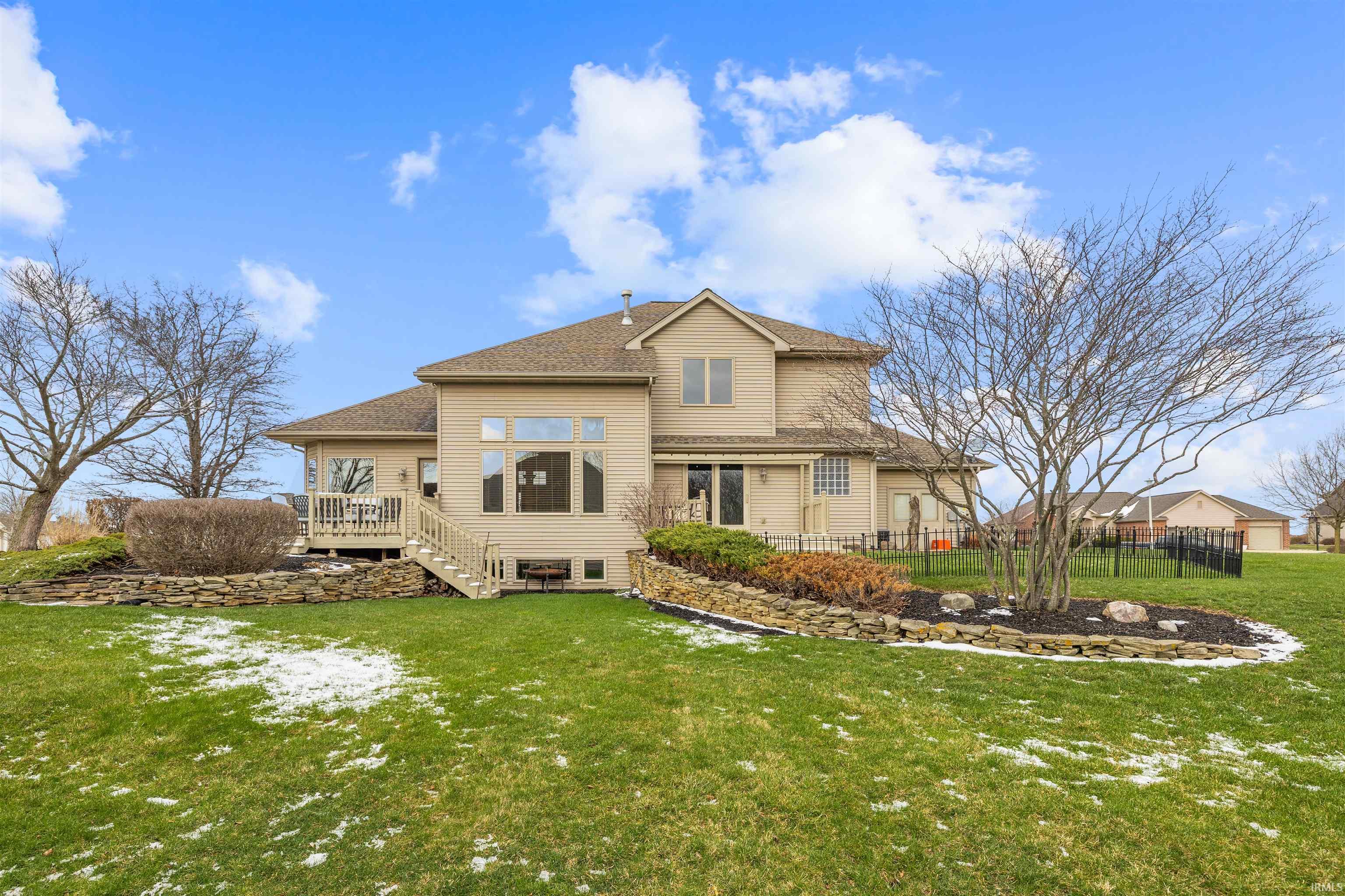 Back of house with a shingled roof and a wooden deck