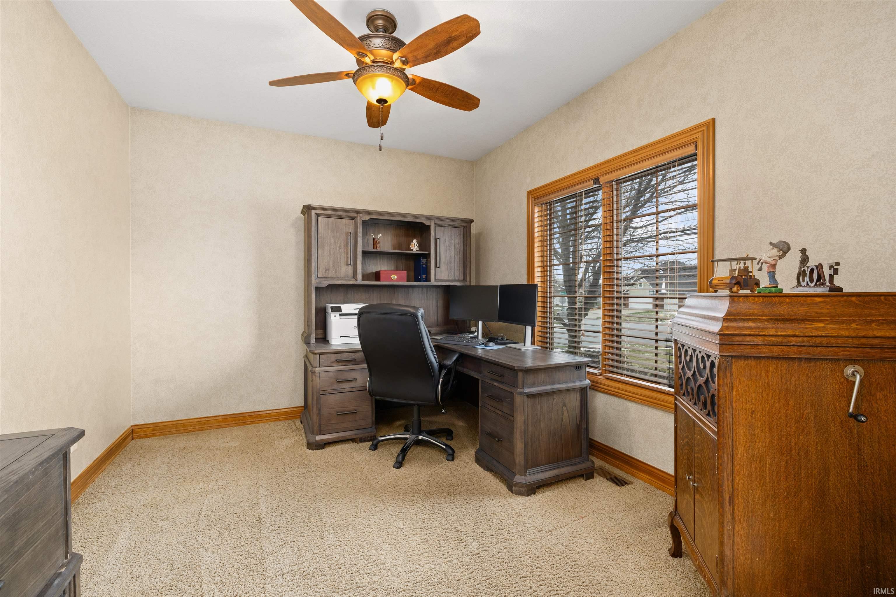 Office space with a ceiling fan and light colored carpet