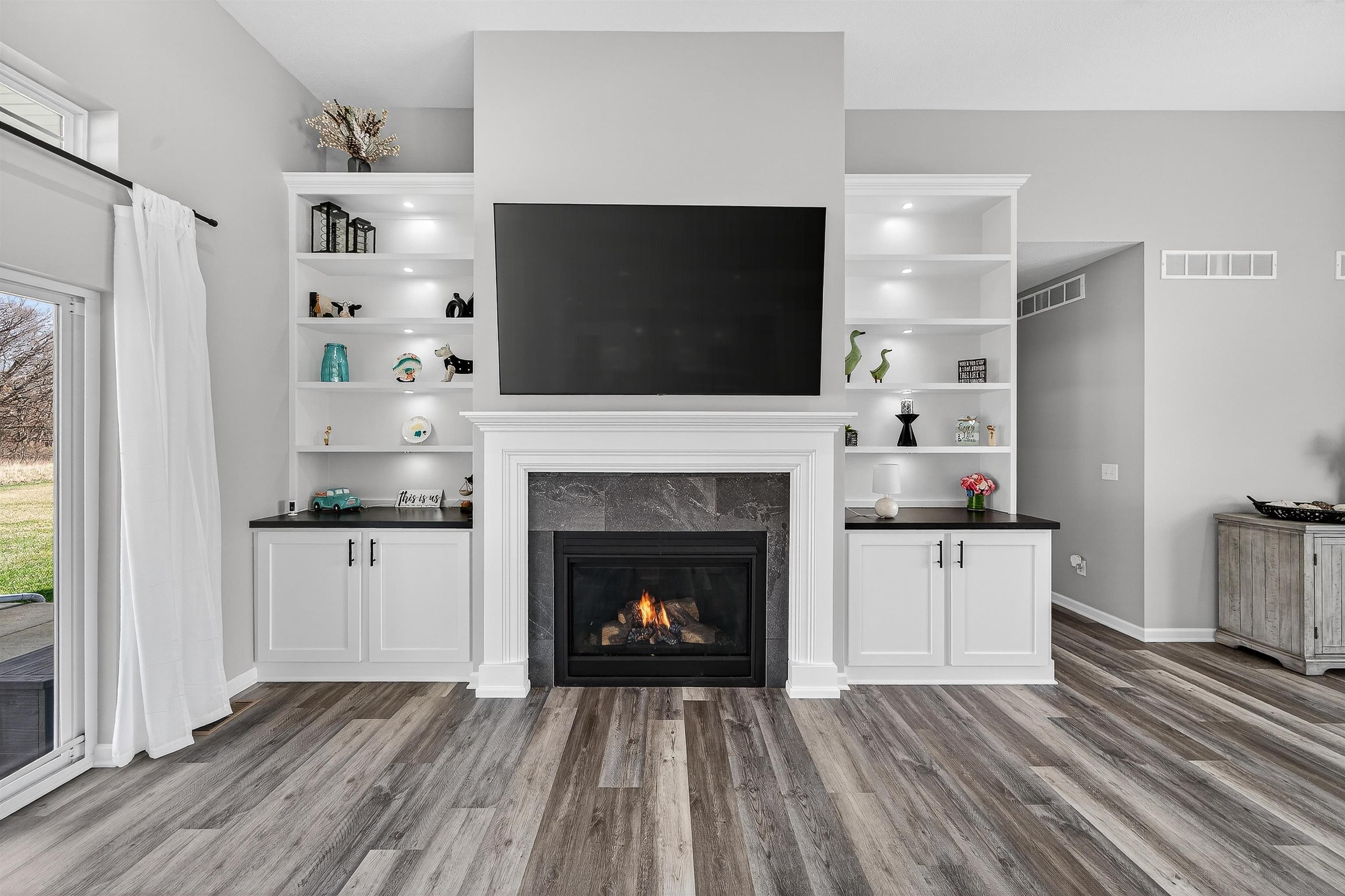 Unfurnished living room with a tile fireplace and dark wood-type flooring