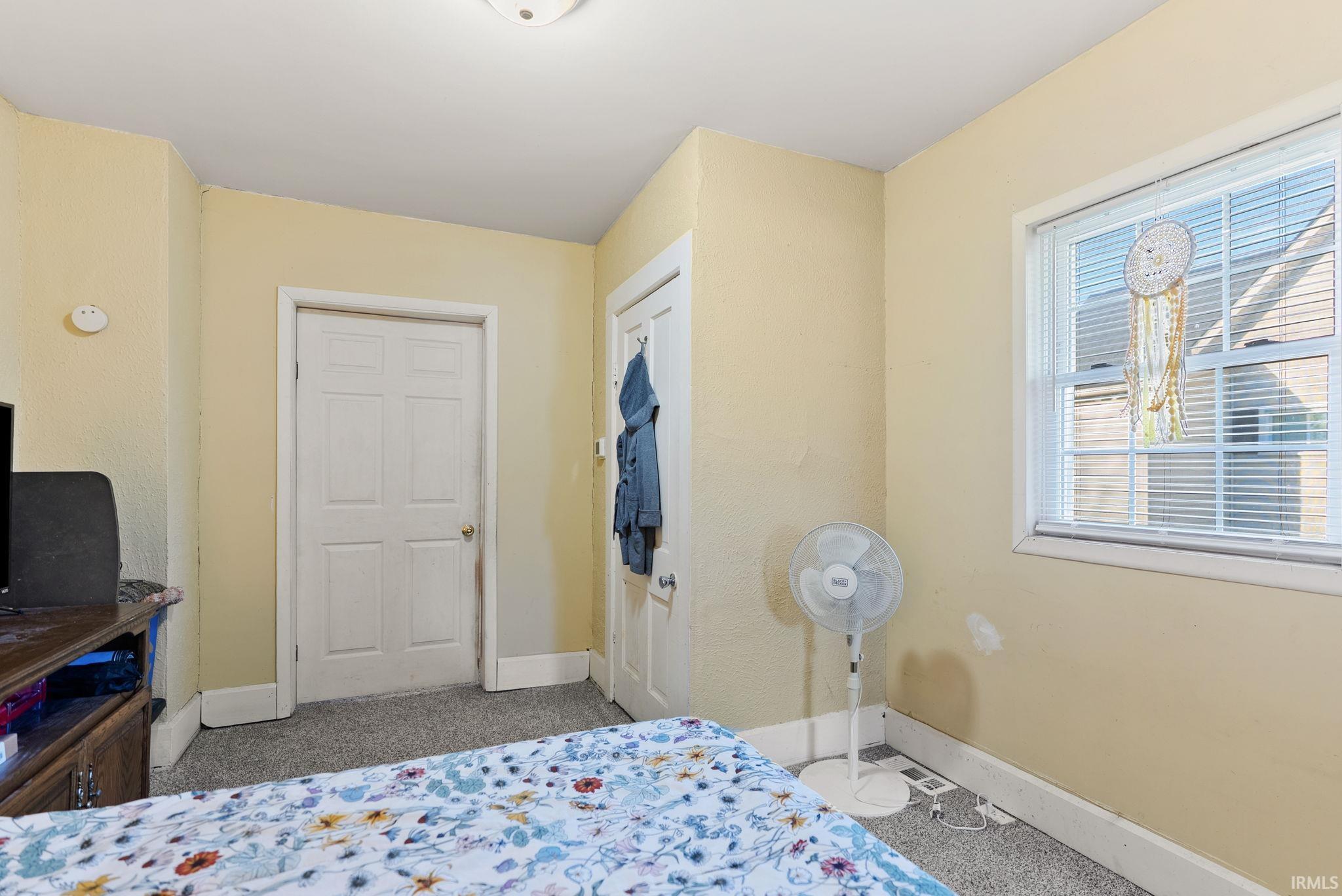 Bedroom featuring light colored carpet and baseboards