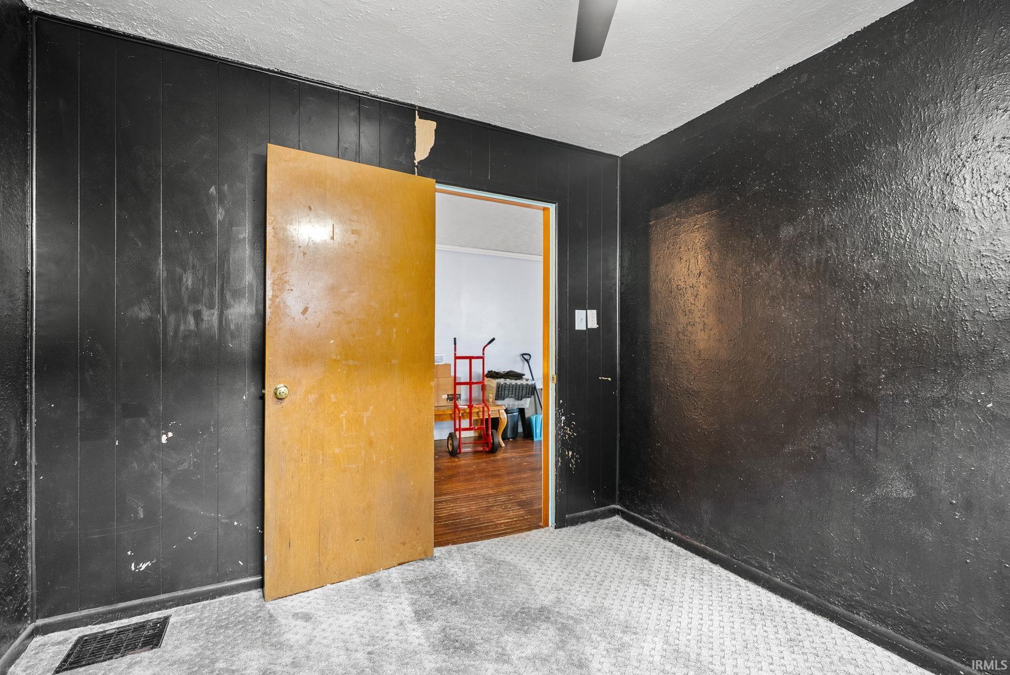 Carpeted spare room with a textured ceiling and ceiling fan