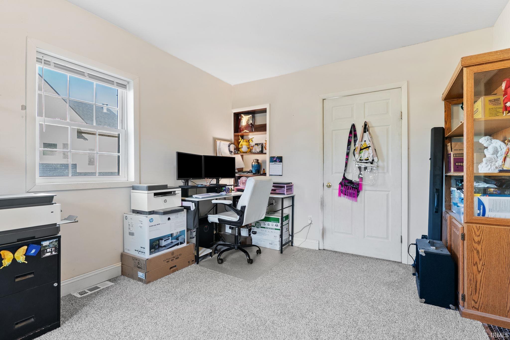 Home office featuring light colored carpet and baseboards