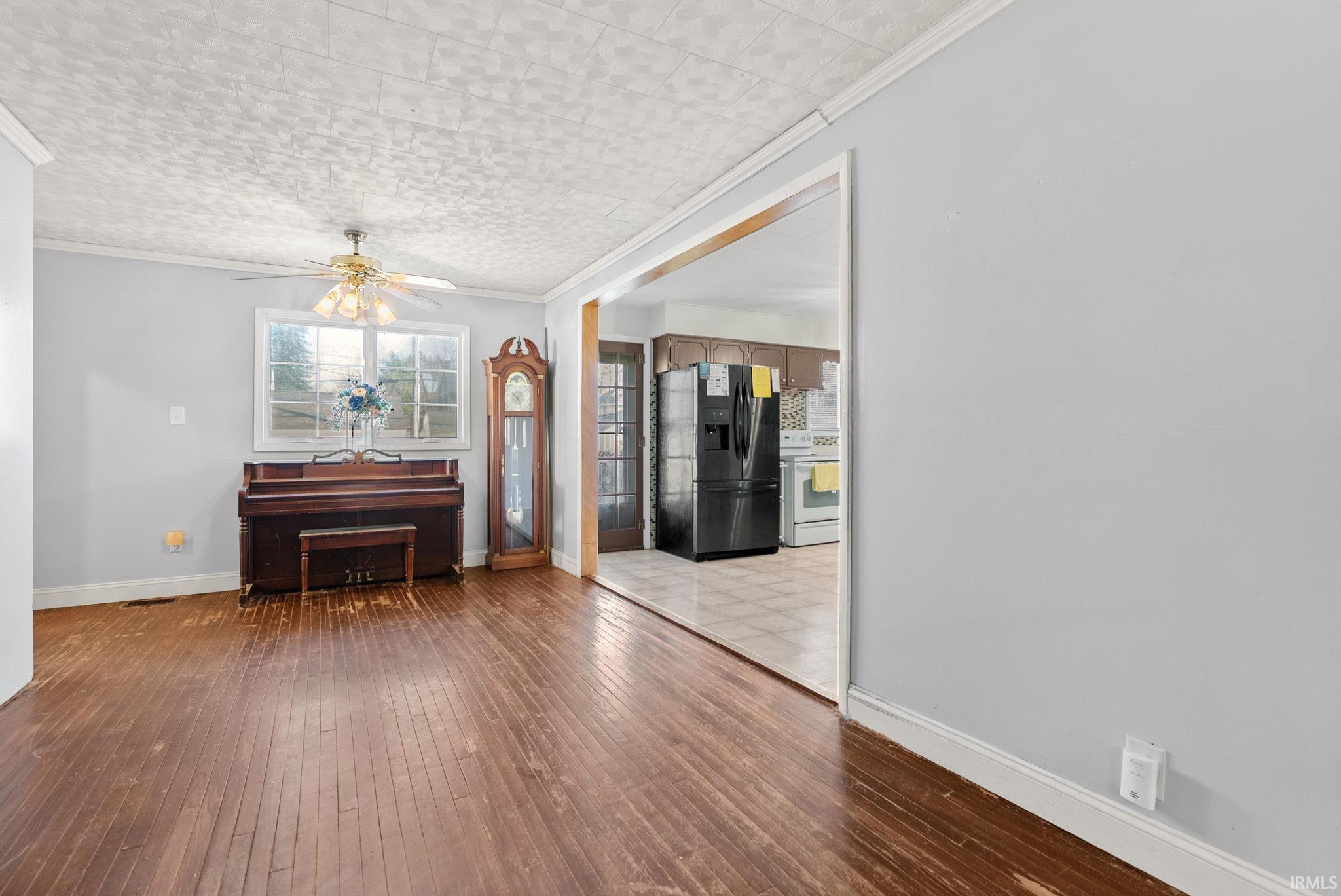 Dining area featuring light wood finished floors, ornamental molding, and a ceiling fan