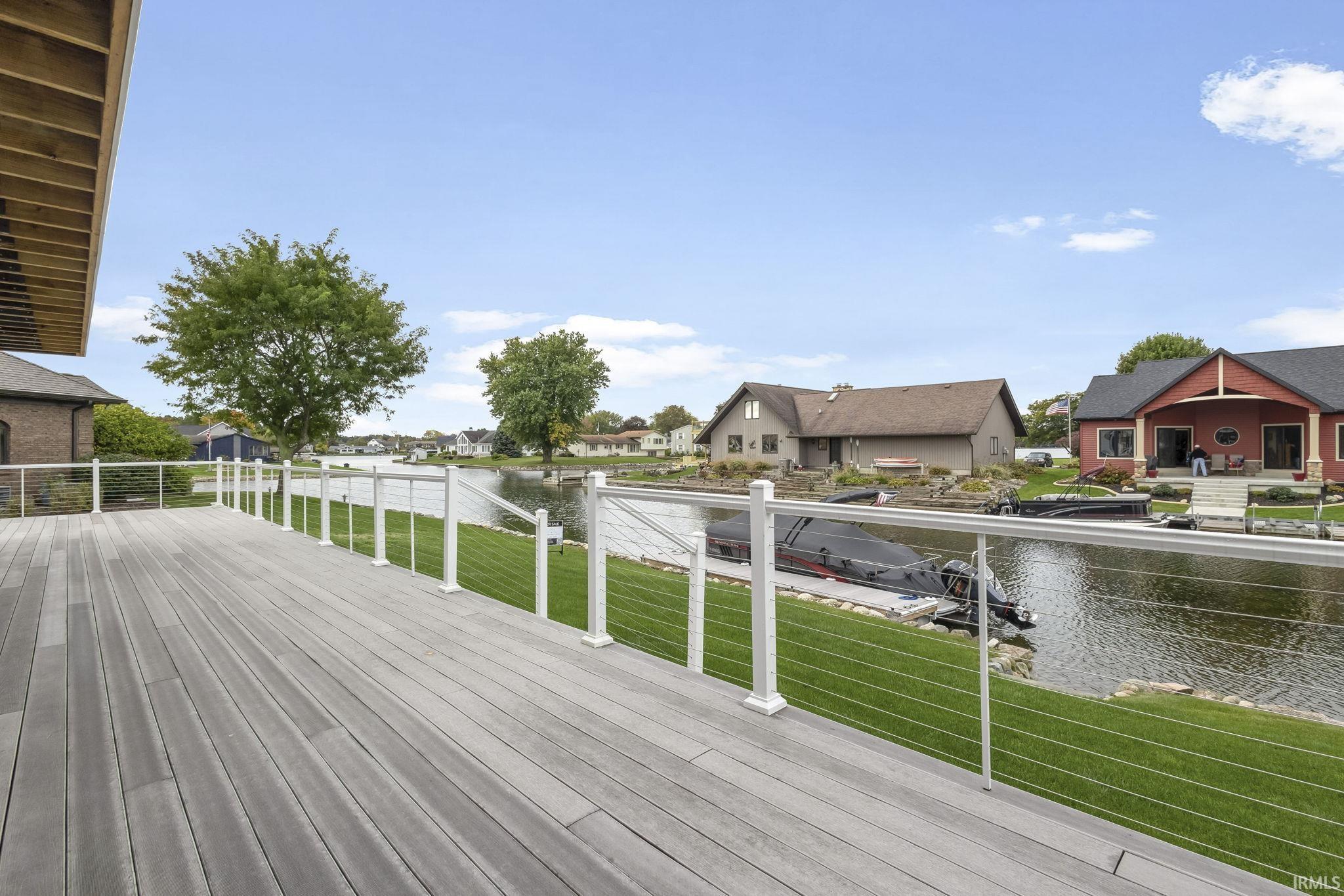 Wooden deck featuring a yard, a residential view, and a water view