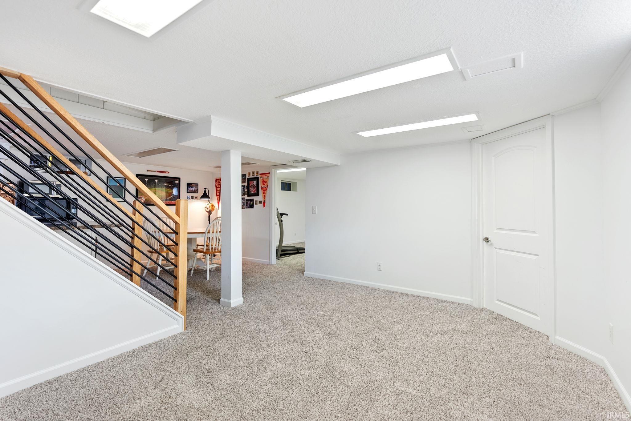 Finished below grade area with stairs and light colored carpet