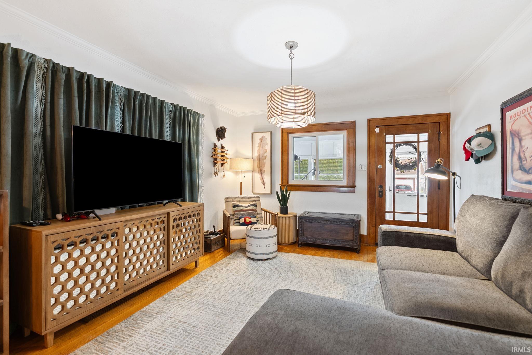 Living room featuring light wood-type flooring and crown molding