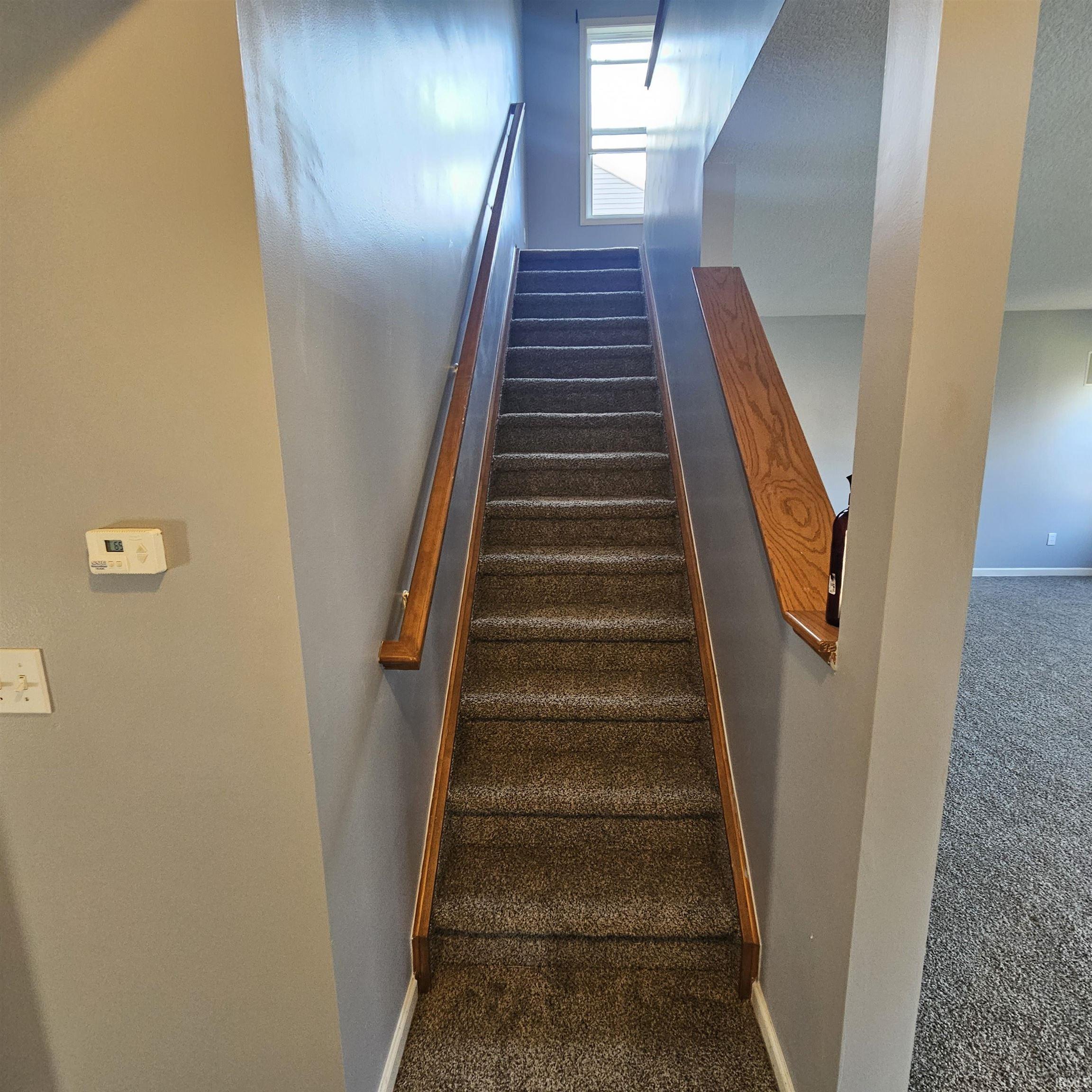 Stairway with carpet floors and baseboards
