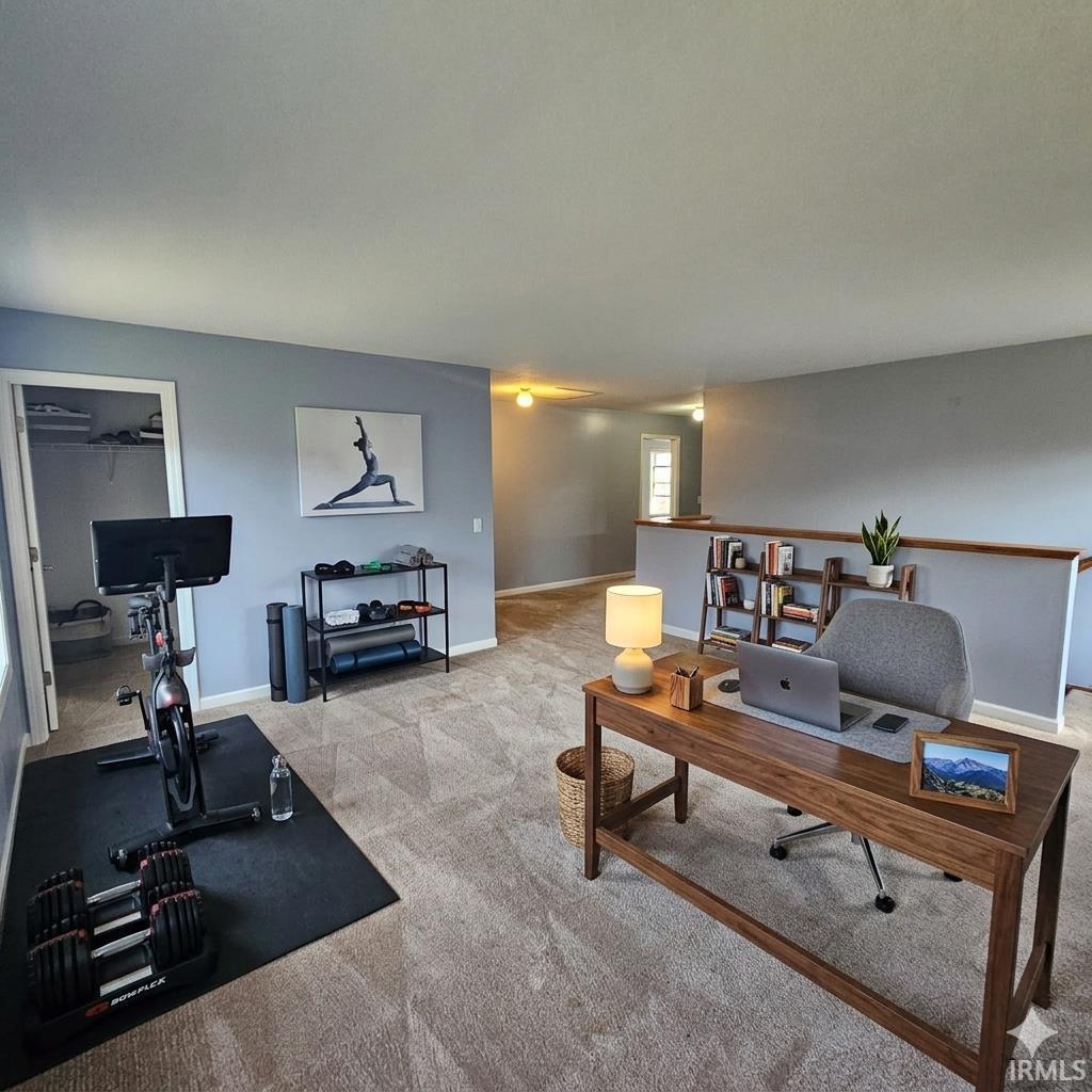 Home office featuring baseboards and light carpet