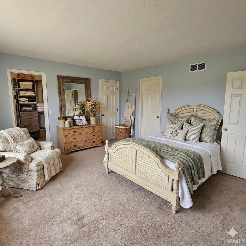 Carpeted bedroom with a spacious closet