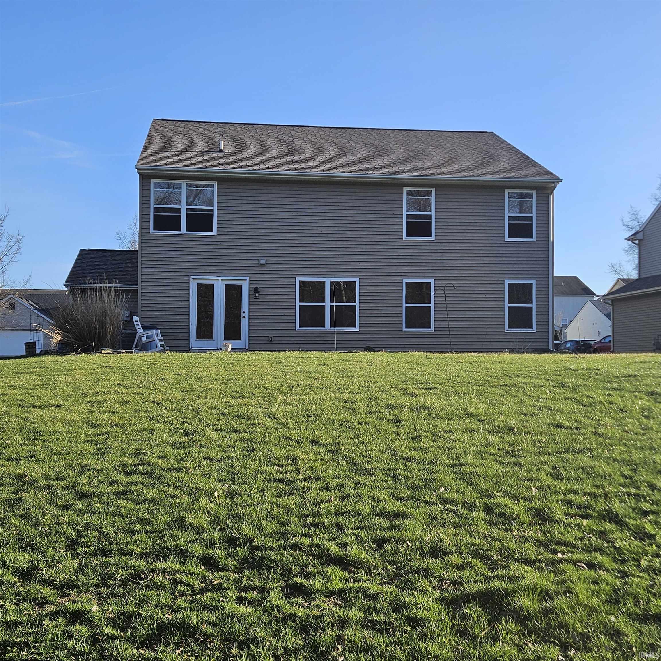 Back of house with a lawn