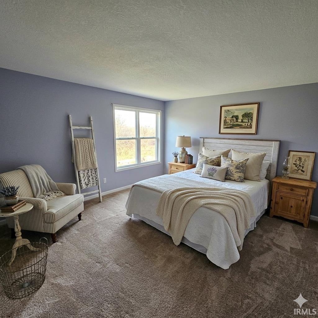 Carpeted bedroom featuring a textured ceiling and baseboards