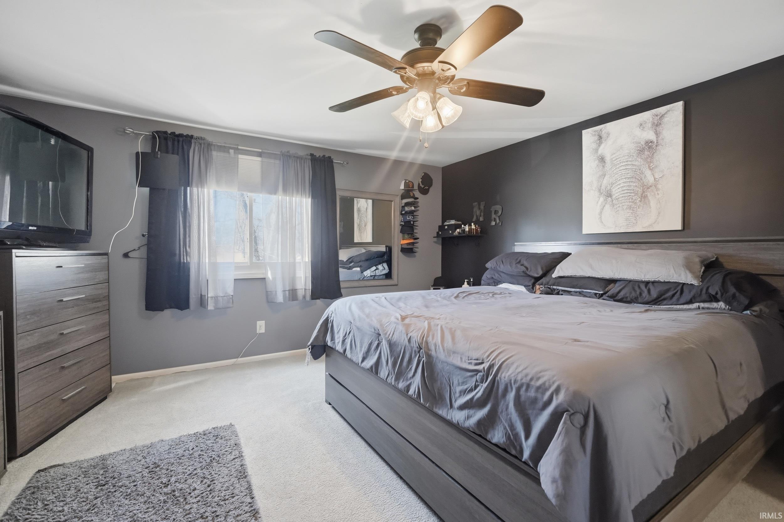 Bedroom with light carpet and ceiling fan