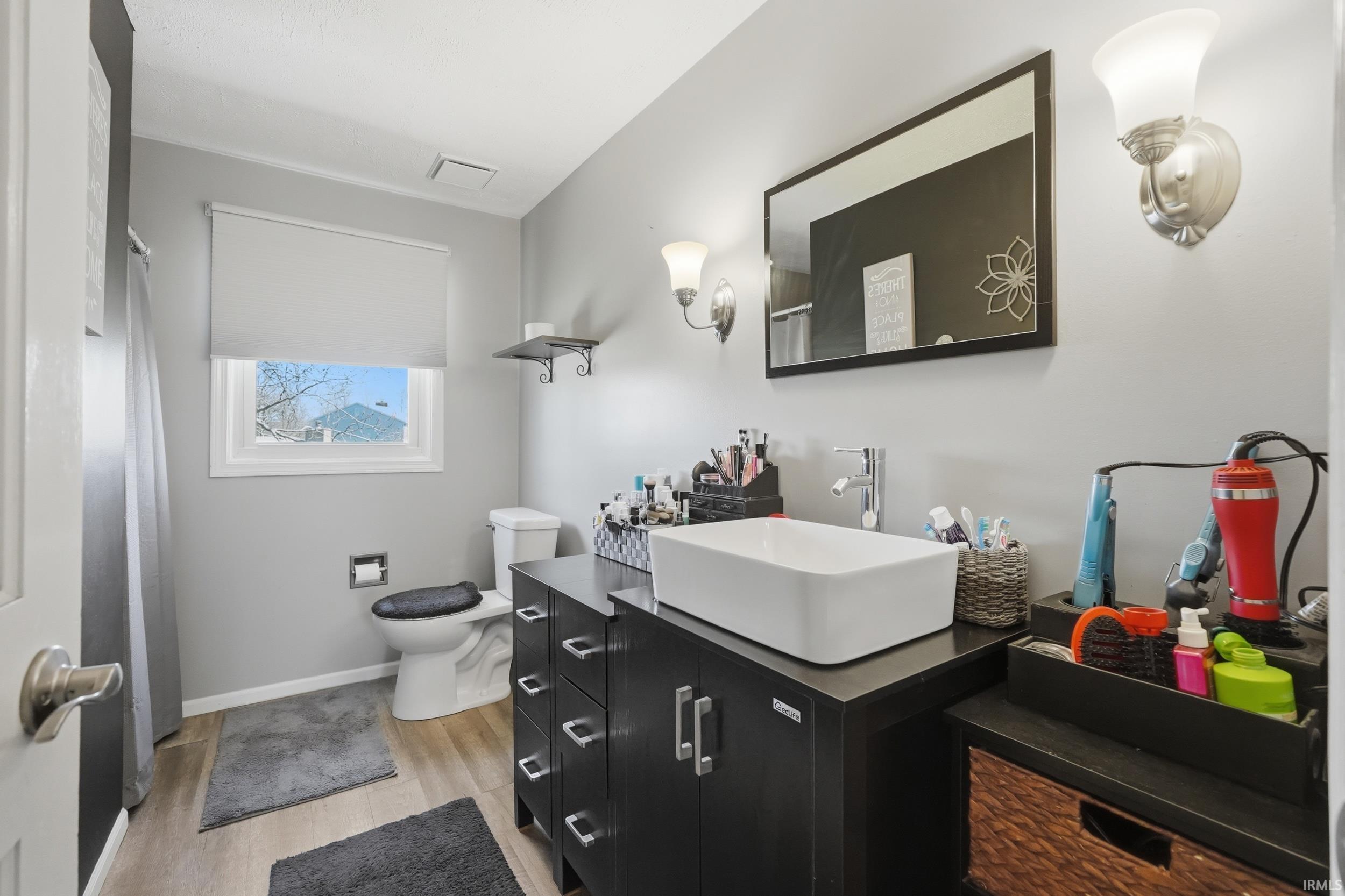 Full bathroom with vanity, light wood-type flooring, and curtained shower