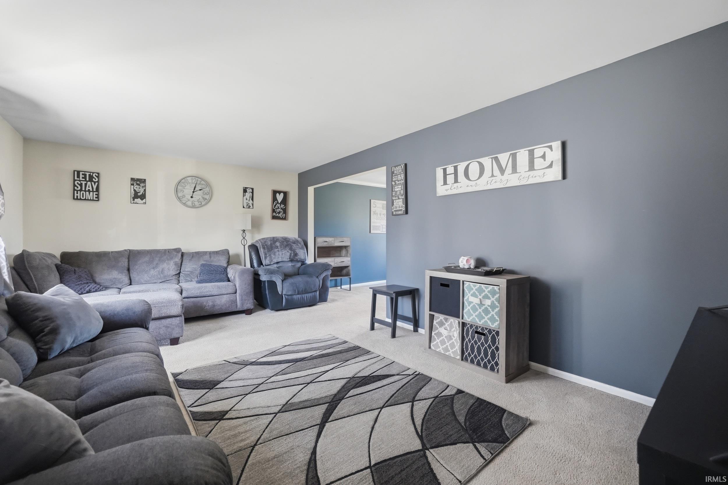 Living area featuring light colored carpet and baseboards