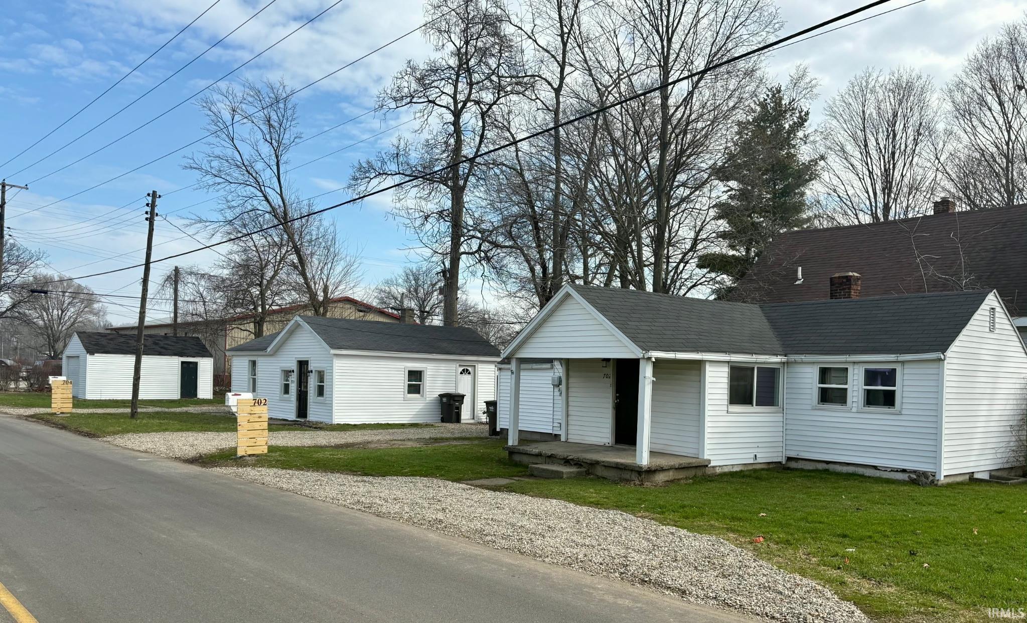 View of front facade with a front yard and roof with shingles