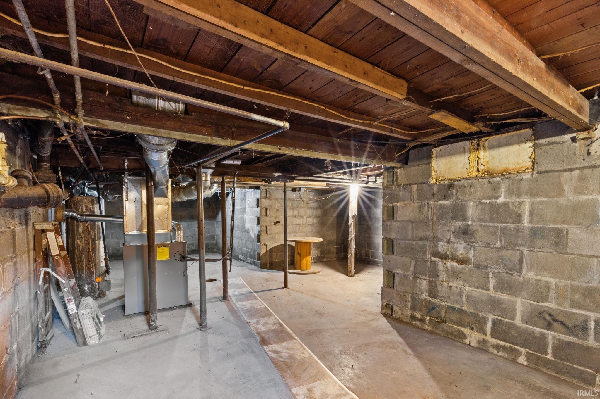 Unfinished basement featuring heating unit