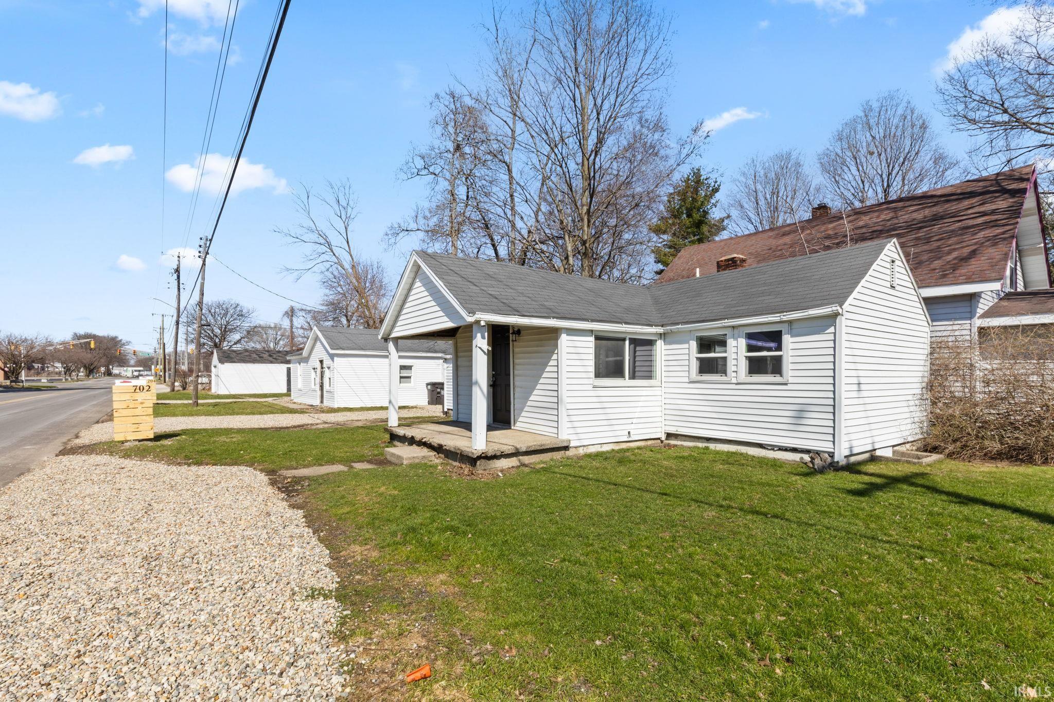 View of front of property with a front yard and roof with shingles