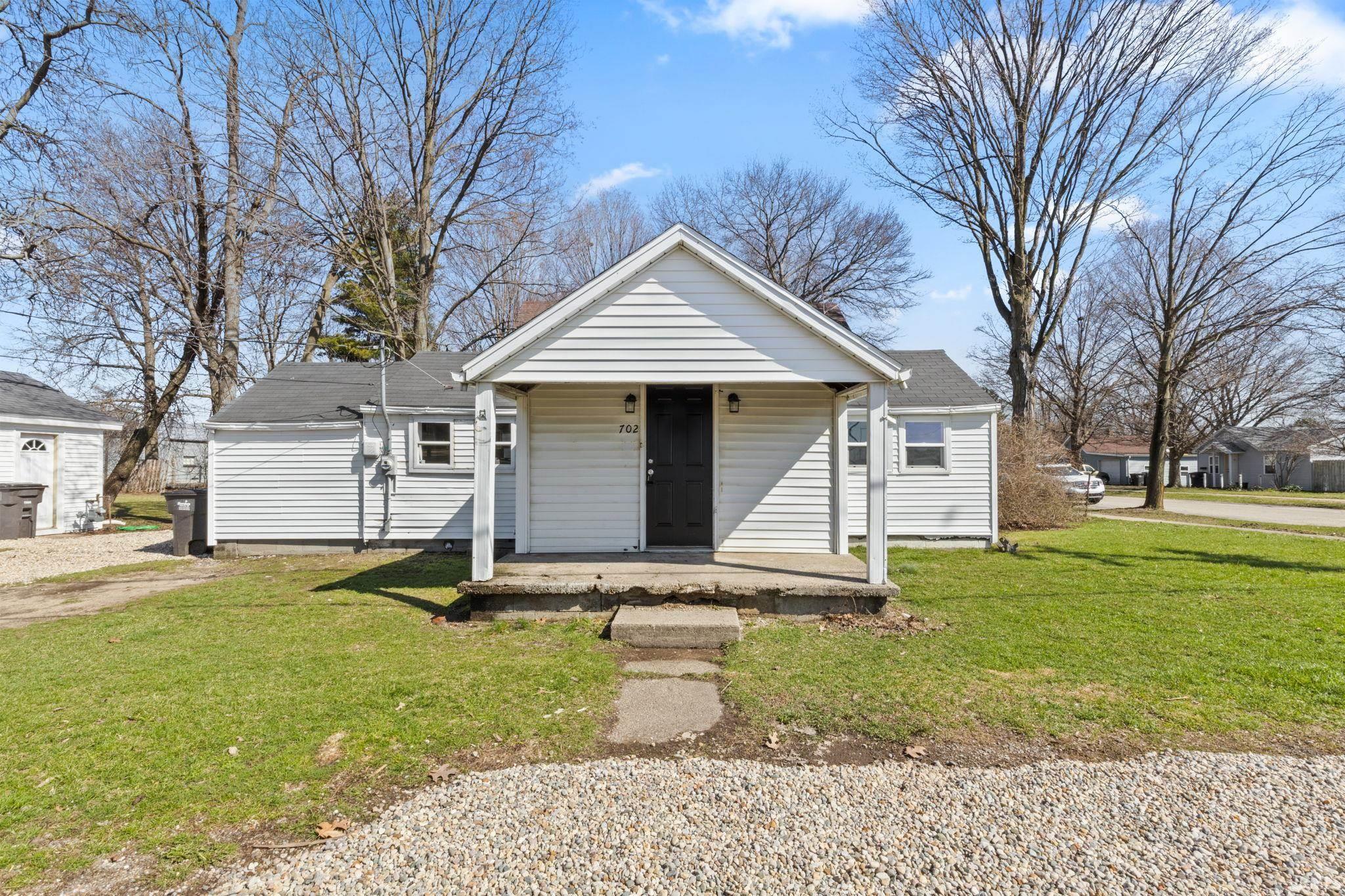 Bungalow-style house with a porch and a front lawn