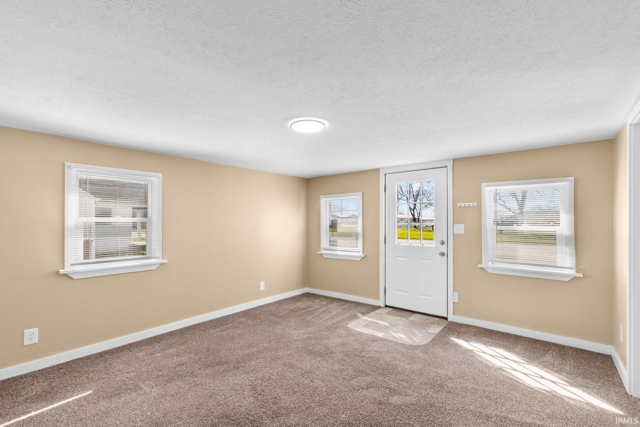 Entrance foyer with carpet floors and a textured ceiling