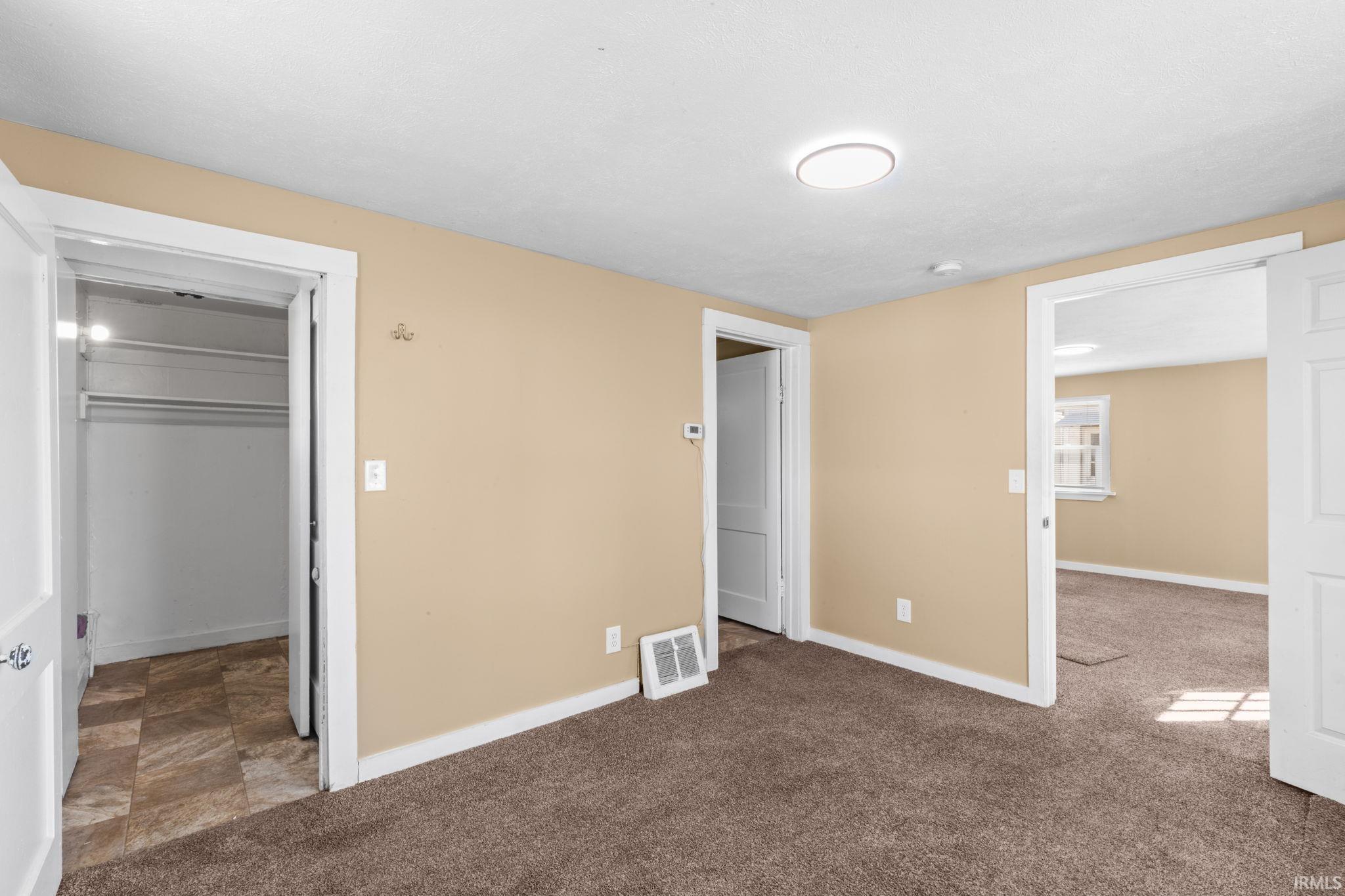 Unfurnished bedroom featuring baseboards and carpet flooring