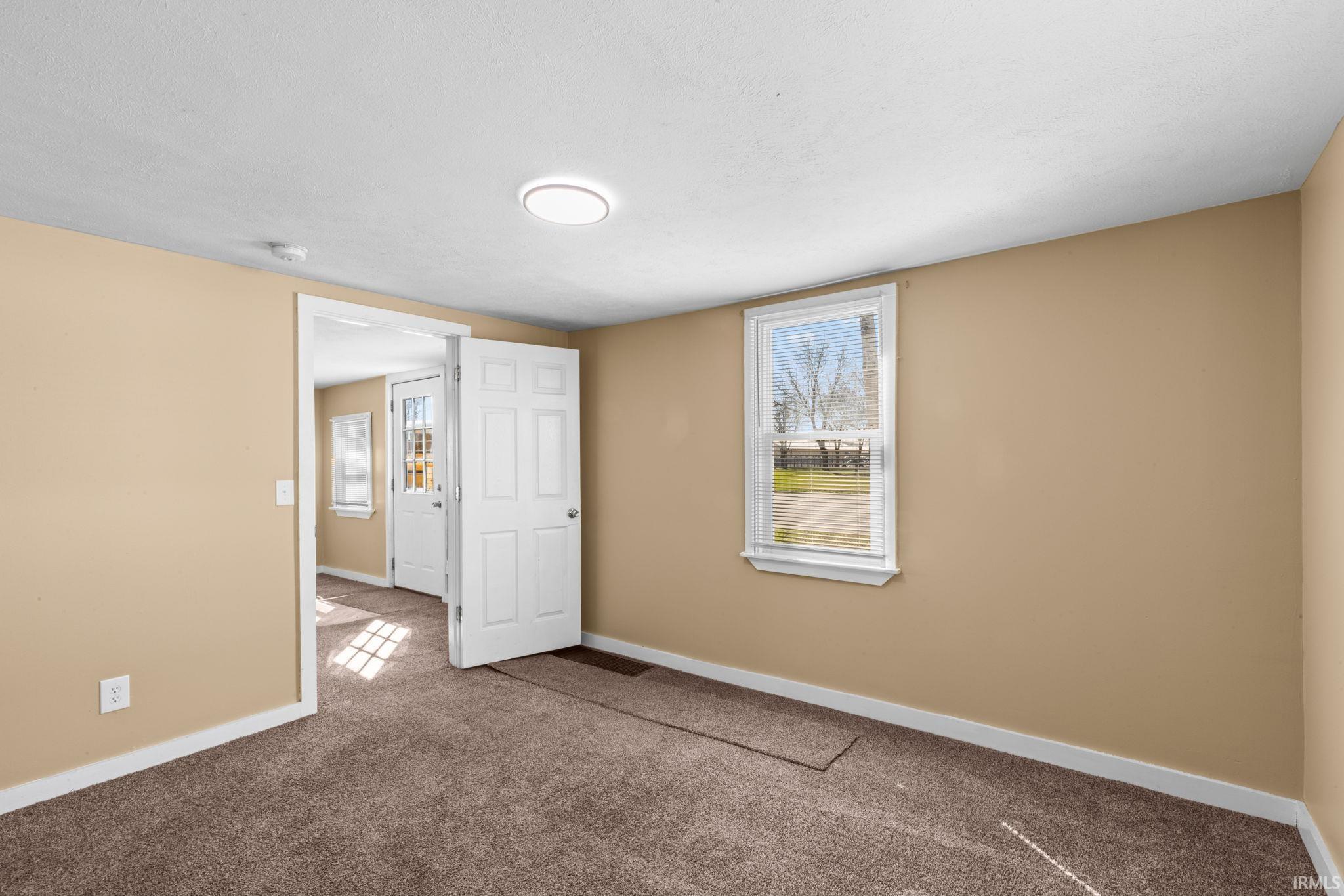 Carpeted spare room with baseboards