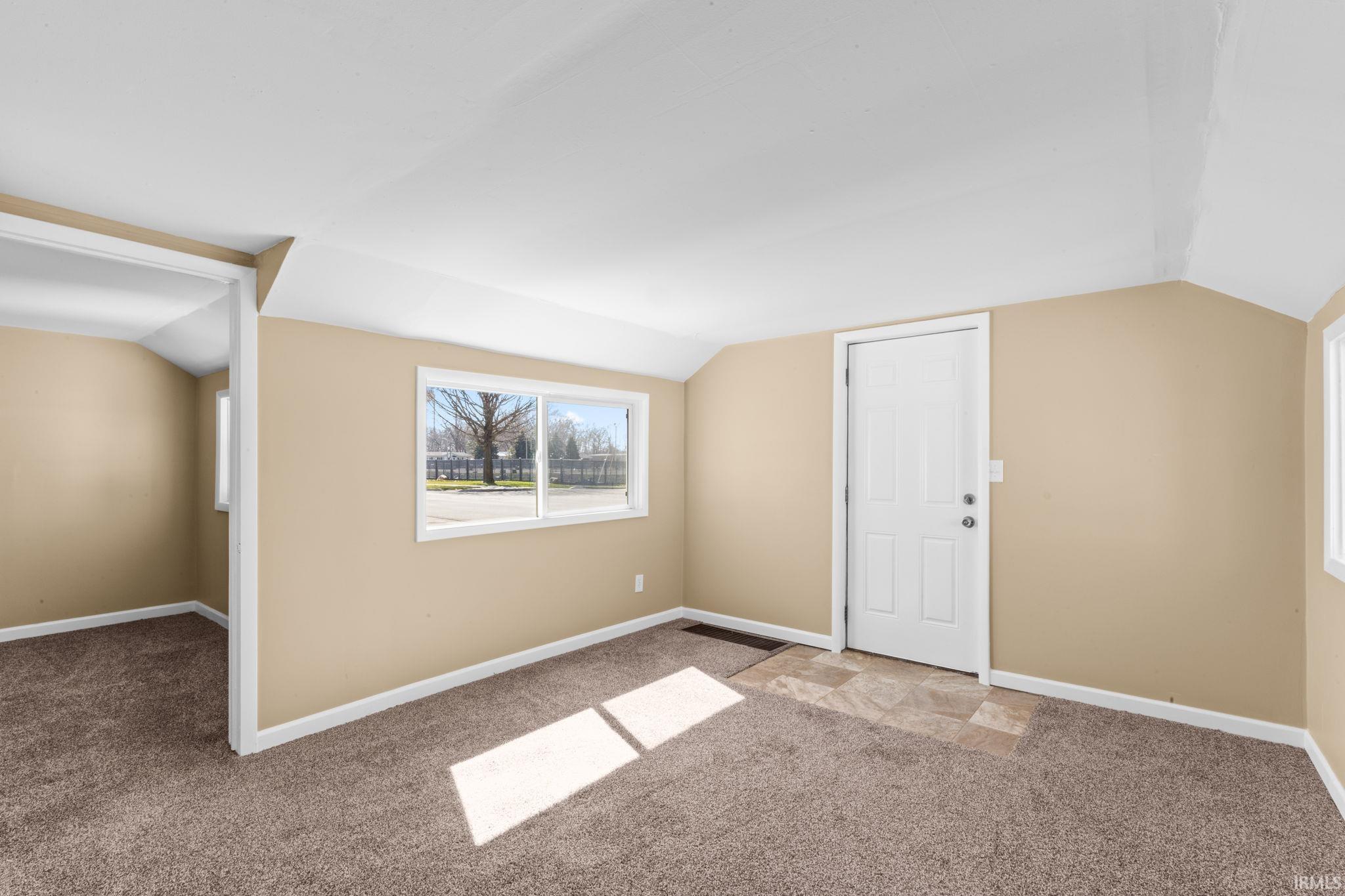 Bonus room featuring lofted ceiling and light colored carpet
