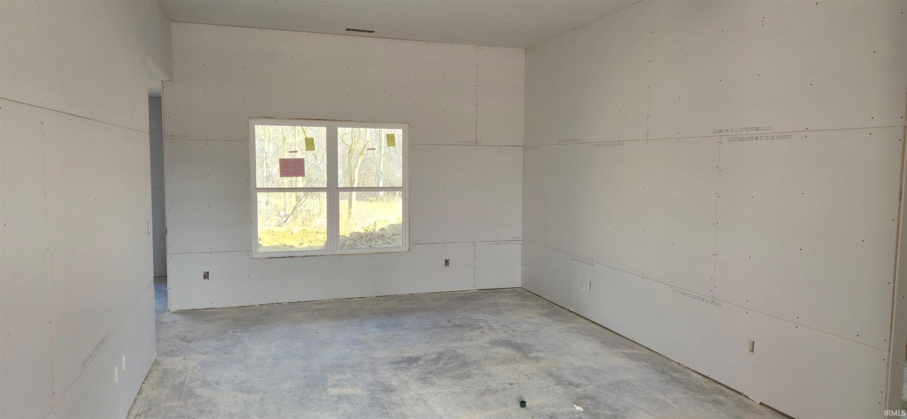 Spare room featuring unfinished concrete flooring