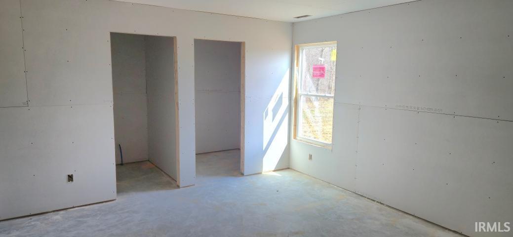 Unfurnished bedroom featuring concrete floors