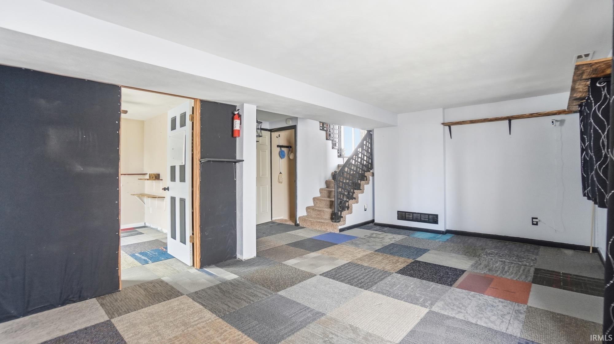Empty room with stairs and baseboards