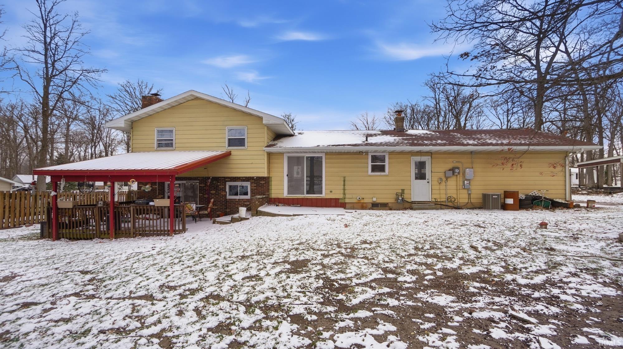 Snow covered house featuring a chimney, a patio, and entry steps