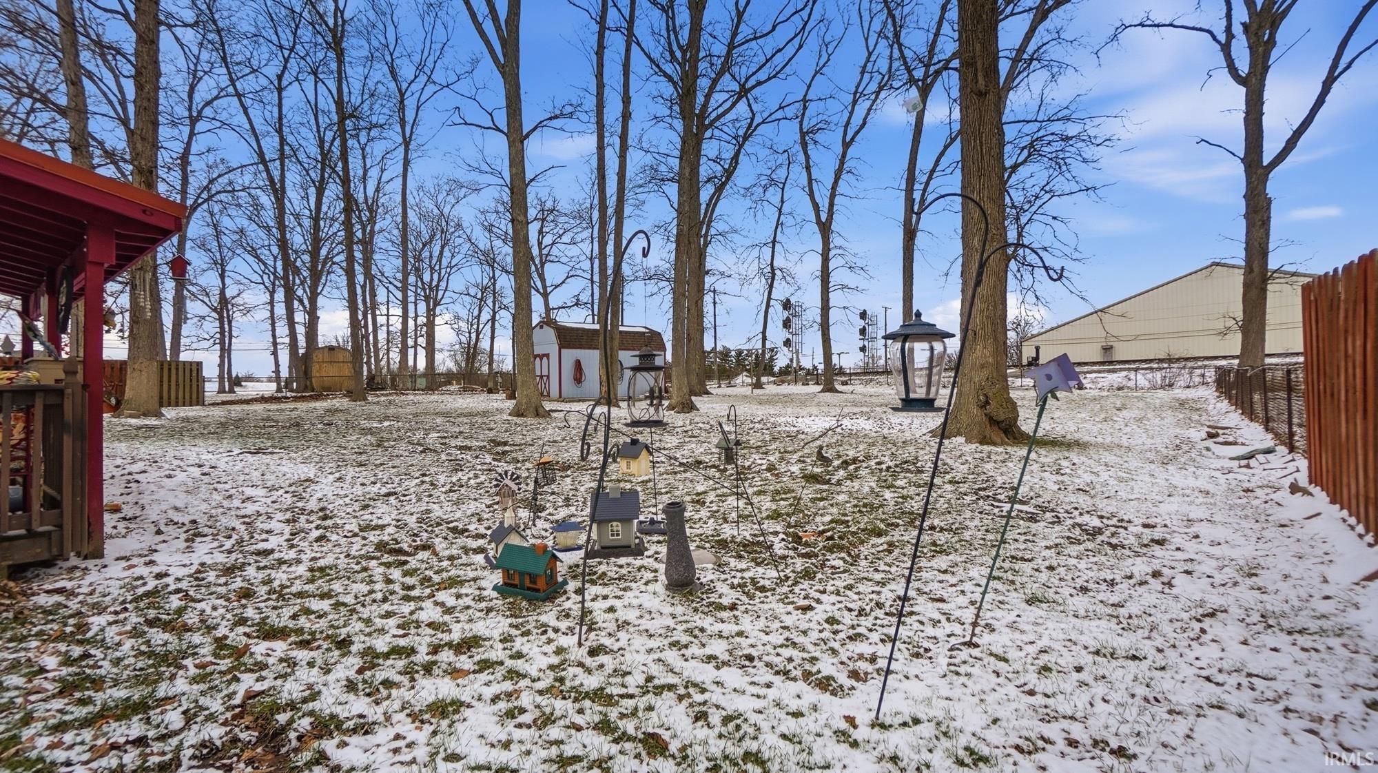 Yard covered in snow featuring a storage unit and a gazebo