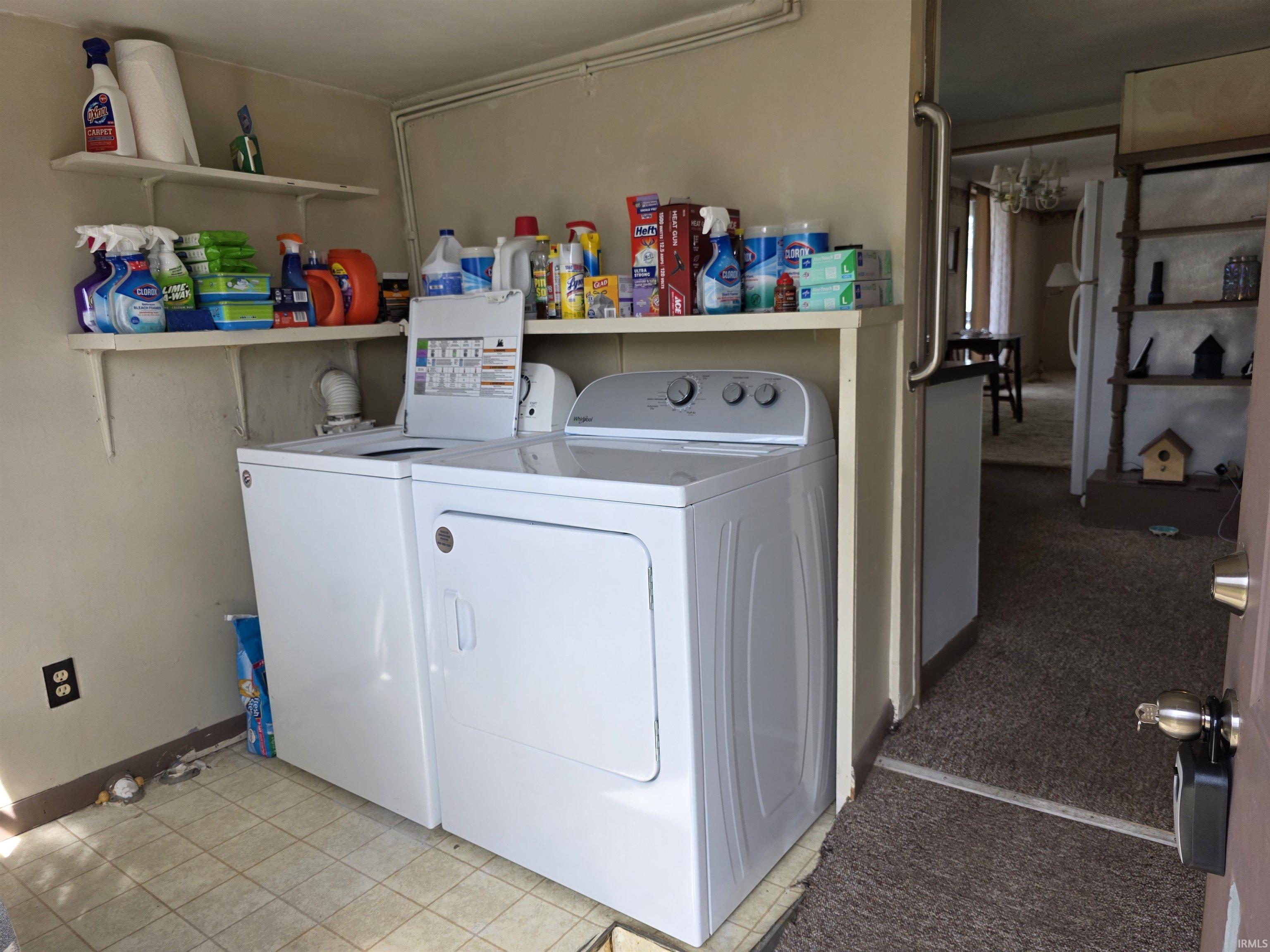 Laundry room featuring independent washer and dryer and light tile patterned flooring
