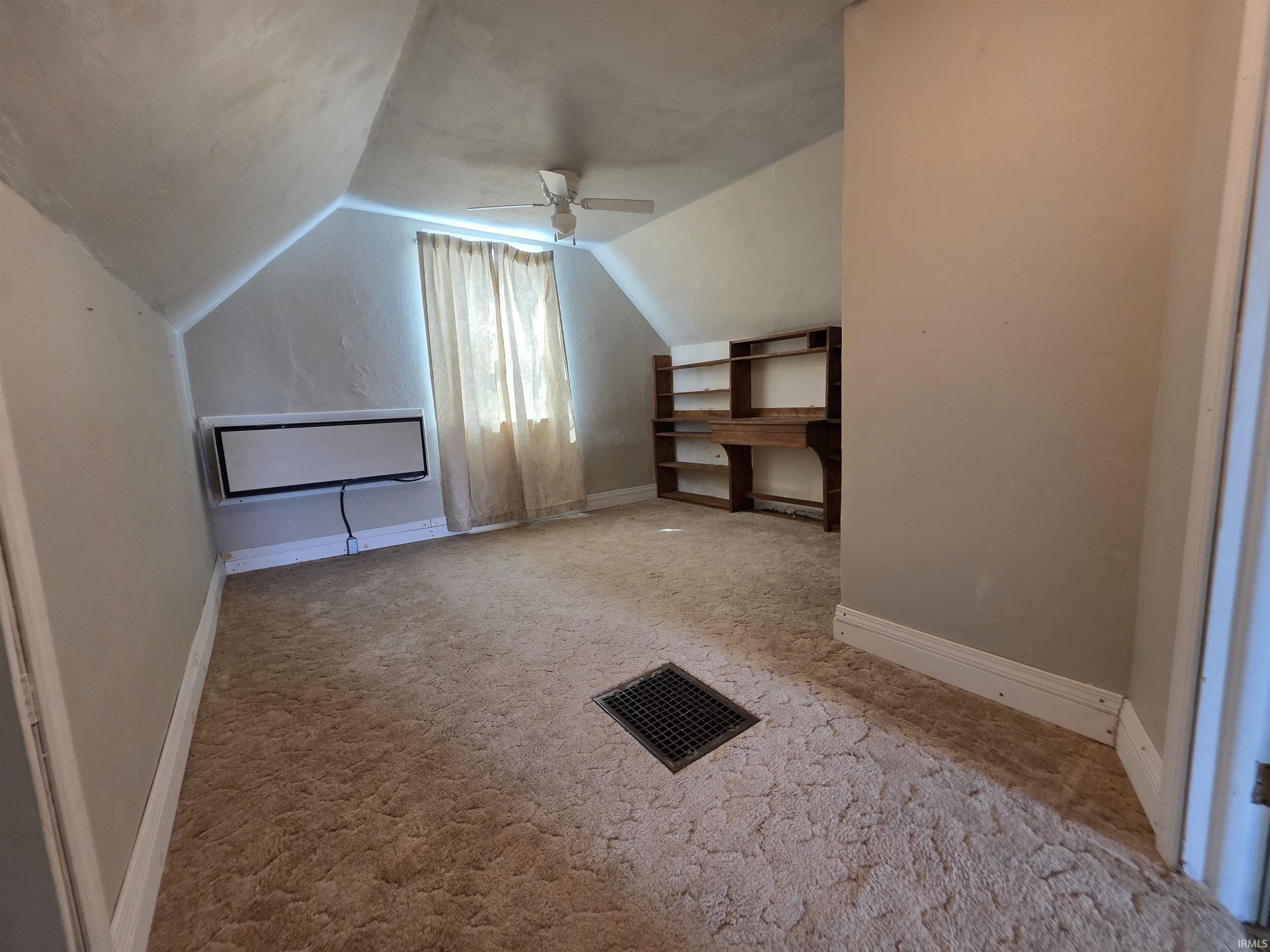 Additional living space with carpet floors and a ceiling fan