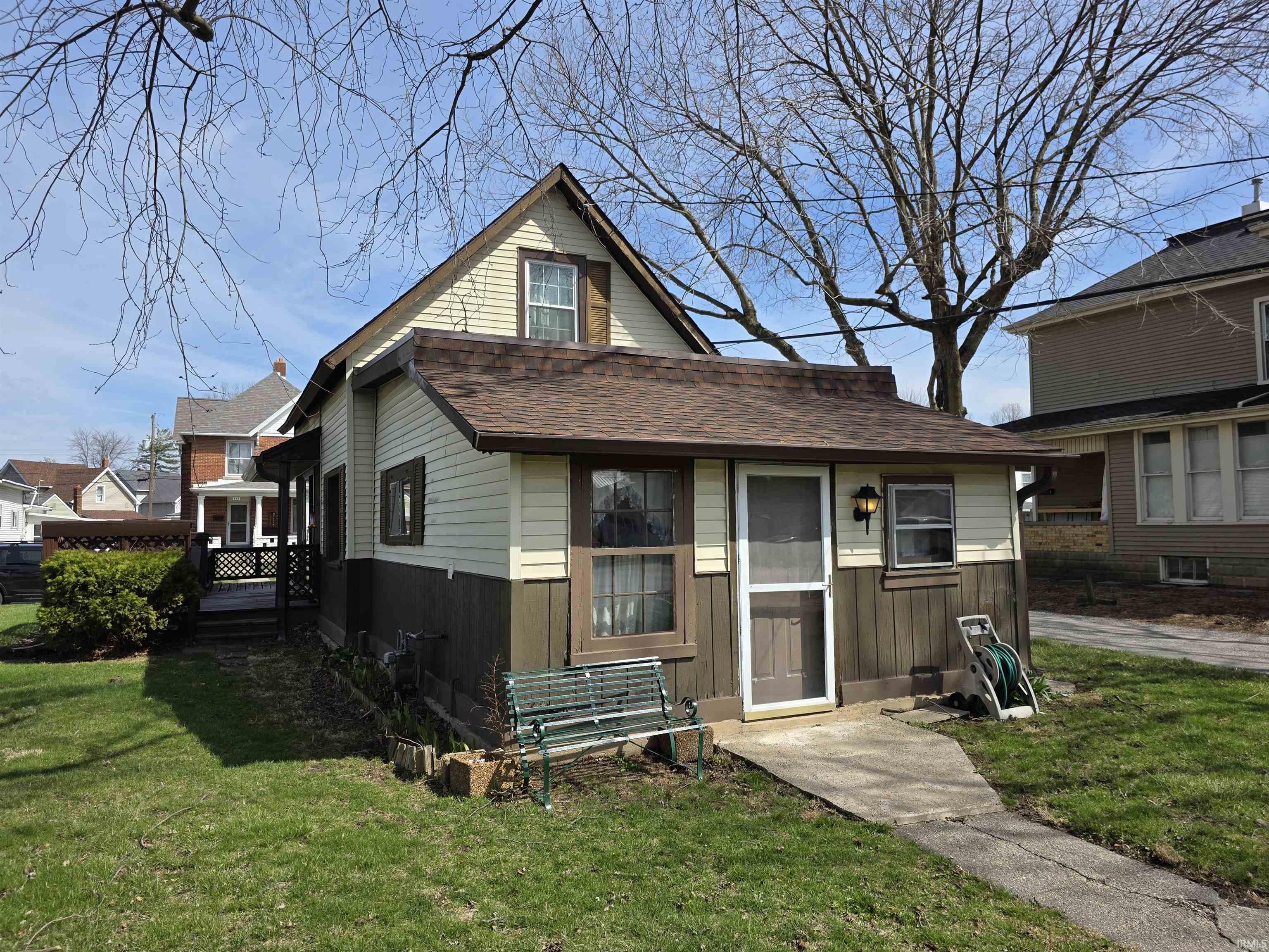 View of front of property with a front lawn and roof with shingles