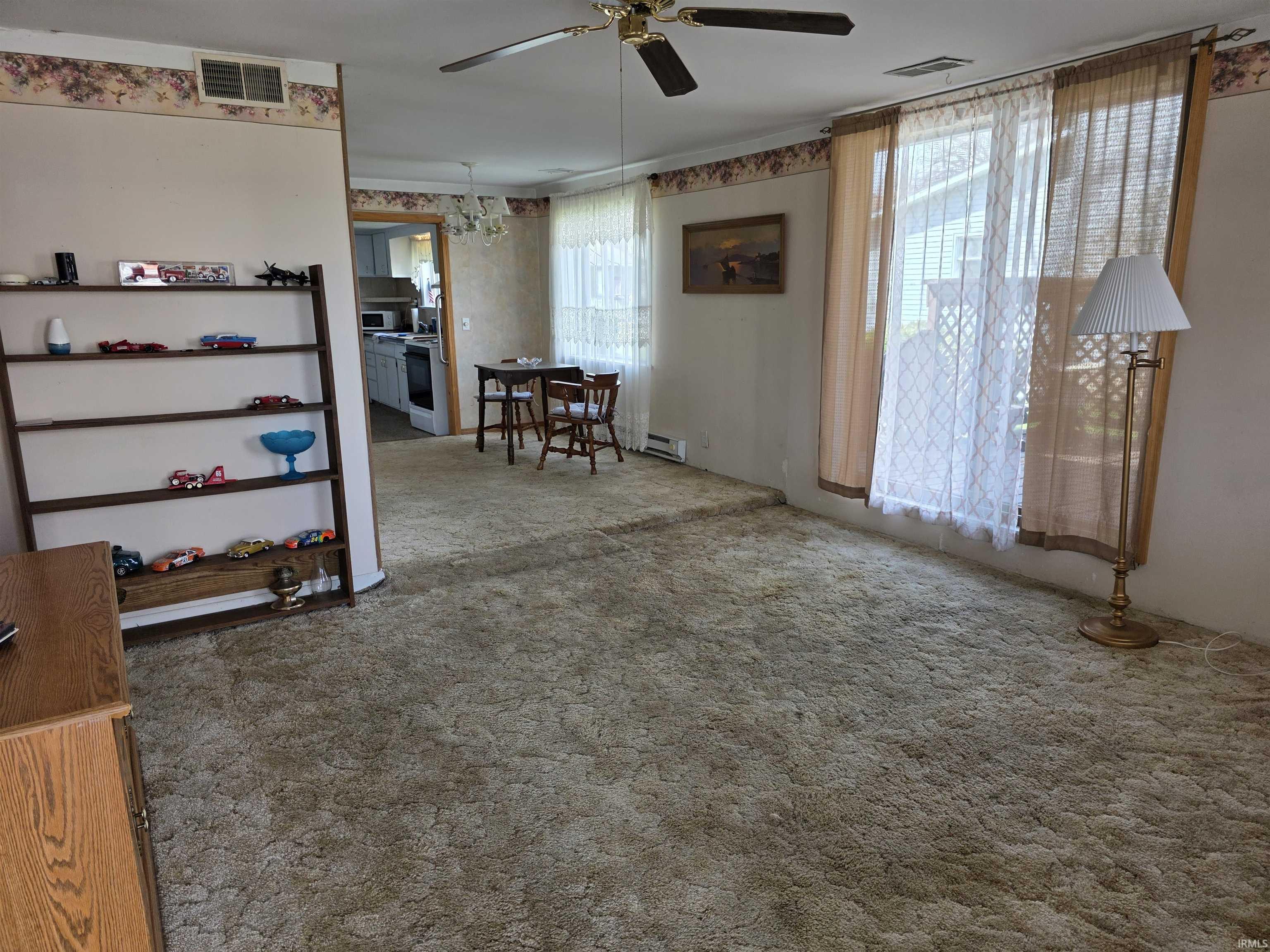 Empty room featuring carpet floors and a ceiling fan